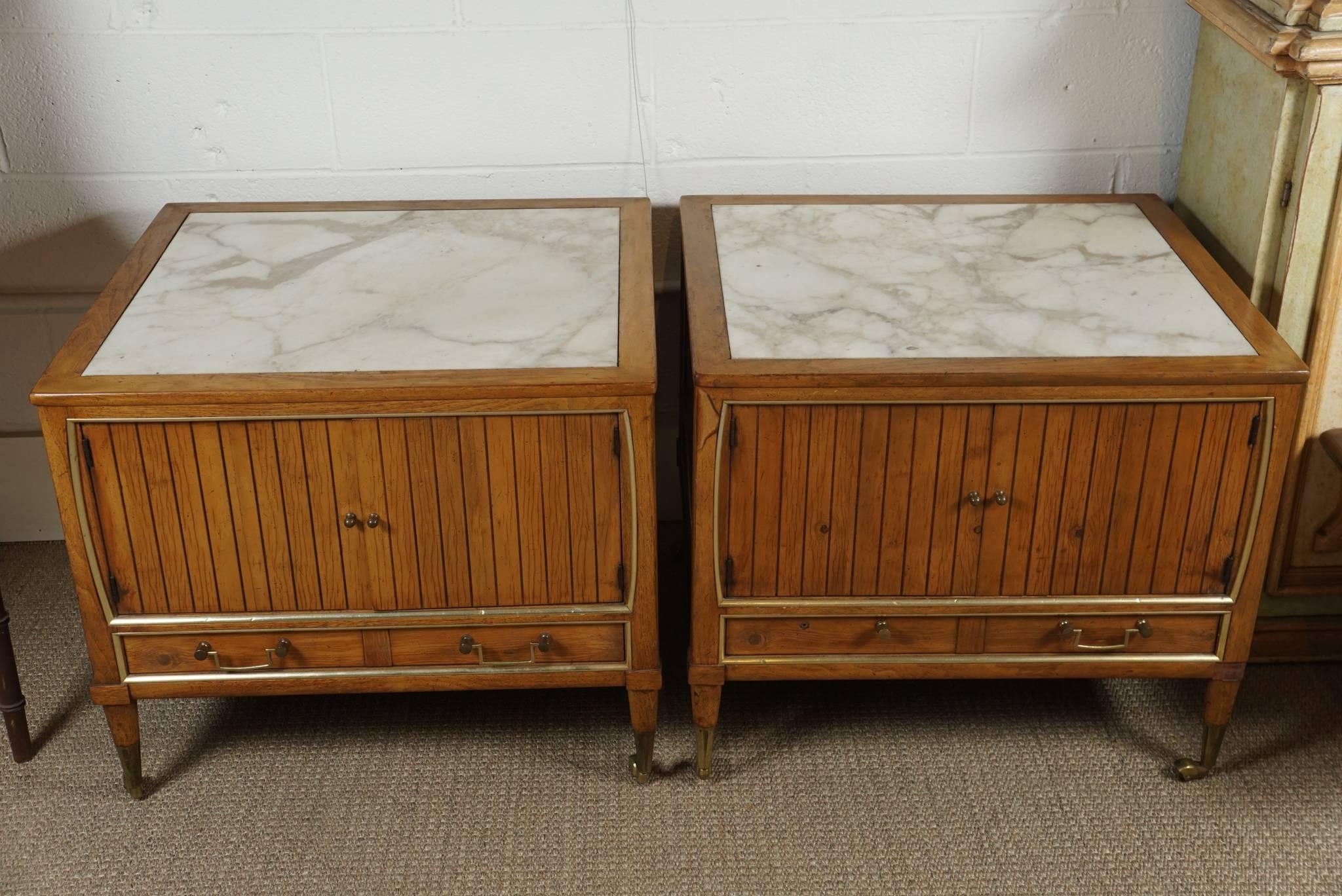 Here are two modern end tables with a maple finish and inset marble tops.
The tables have brass hardware and casters.