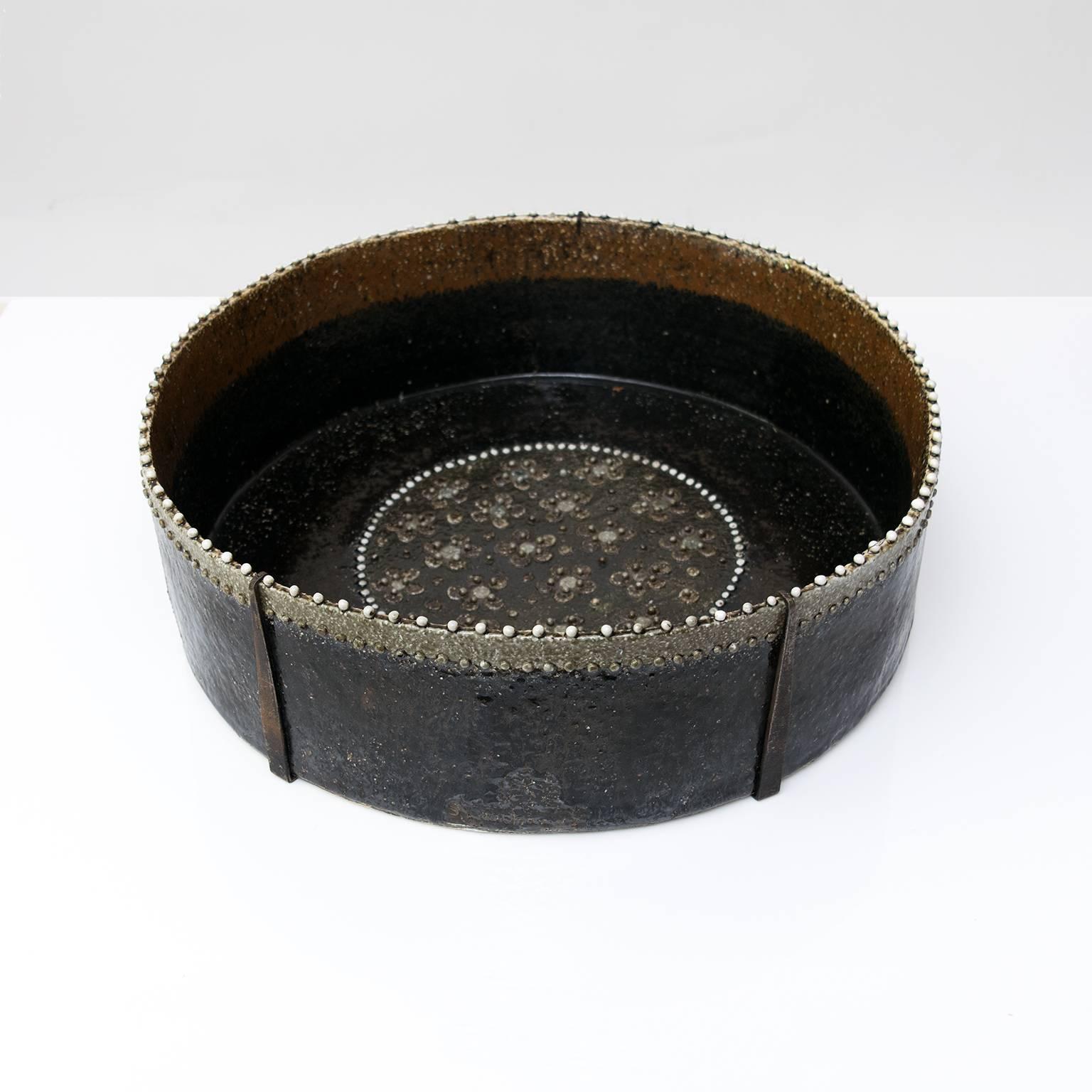 Very large scale Scandinavian Modern ceramic studio bow by Sylvia Leuchovius. The bowl is decorated with small dots and ball contrasted against neutral brown and gray glazes. This piece retains it custom removable wall mount mechanism. 
Measures:-