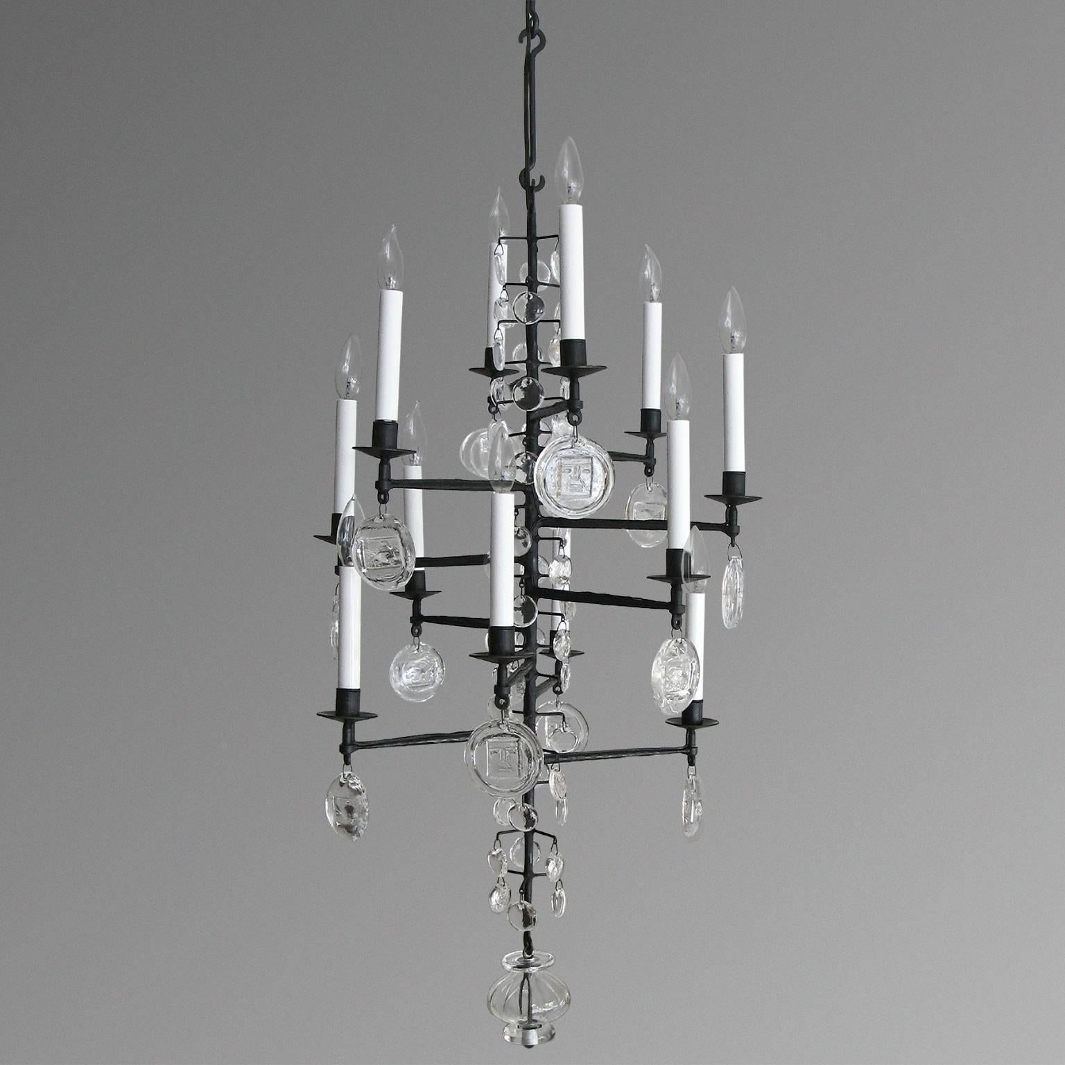Scandinavian Modern wrought iron chandelier with clear crystals, newly electrified 12 candelabra base lights. Made by Boda Nova Glassworks/Axel Stromberg Ironwork, Sweden. Measures: H: 39
