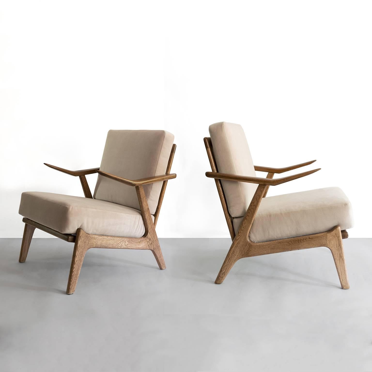 Pair of Scandinavian modern "Janus" armchairs by Kurt Ostervig for Randers Møbelfabrik, Denmark. The chair's frames are solid oak and feature angled solid teak arms. Newly restored in excellent condition with newly upholstered velvet