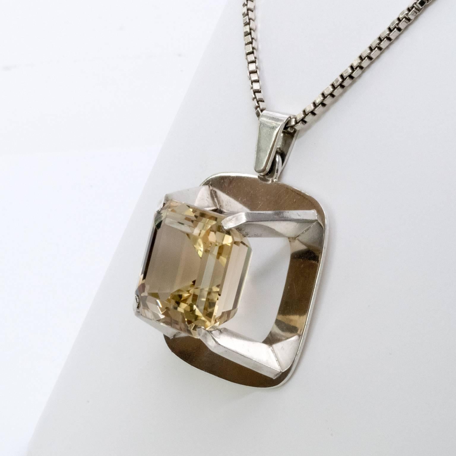 A Scandinavian Modern silver necklace with a rounded rectangular pendant with a dramatic, mounted citron rock crystal. Designed by Birger Lindgren, 1967, Stockholm Sweden.

Pendant: Height 2.5", width 2".
Chain 31.5" long.