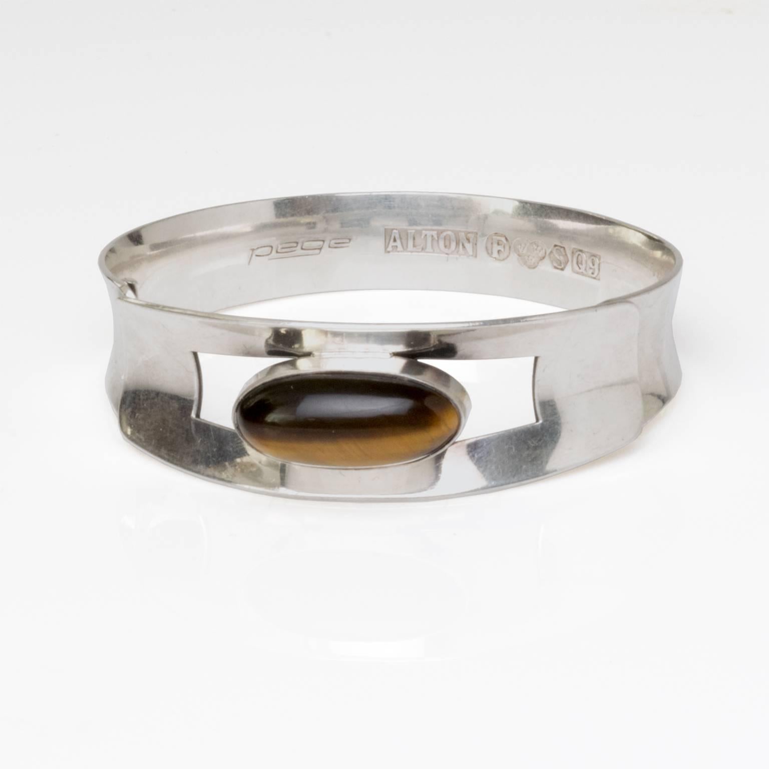 Skandinavisches modernes Silberarmband mit ovalem Tigerauge Stein. Signiert Pege, hergestellt von Alton, Schweden, 1966.
Misst Durchmesser 2,5