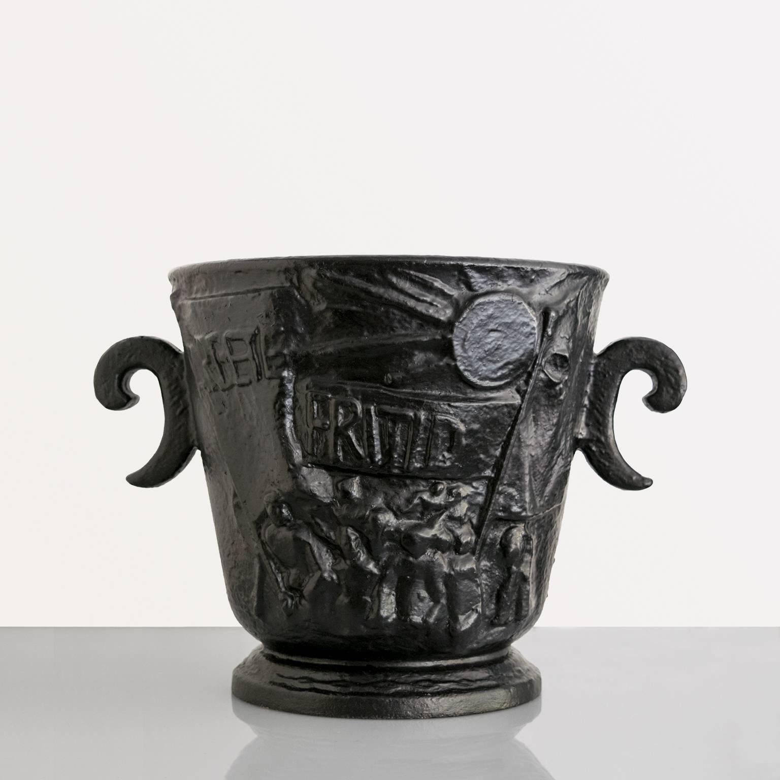 A large Scandinavian Modern cast iron "Leisure Urn" depicting cultural arts on one side and the demand for social change during the 1930s. One side has marching workers carrying banners which read "Arbete Fritid" the other side