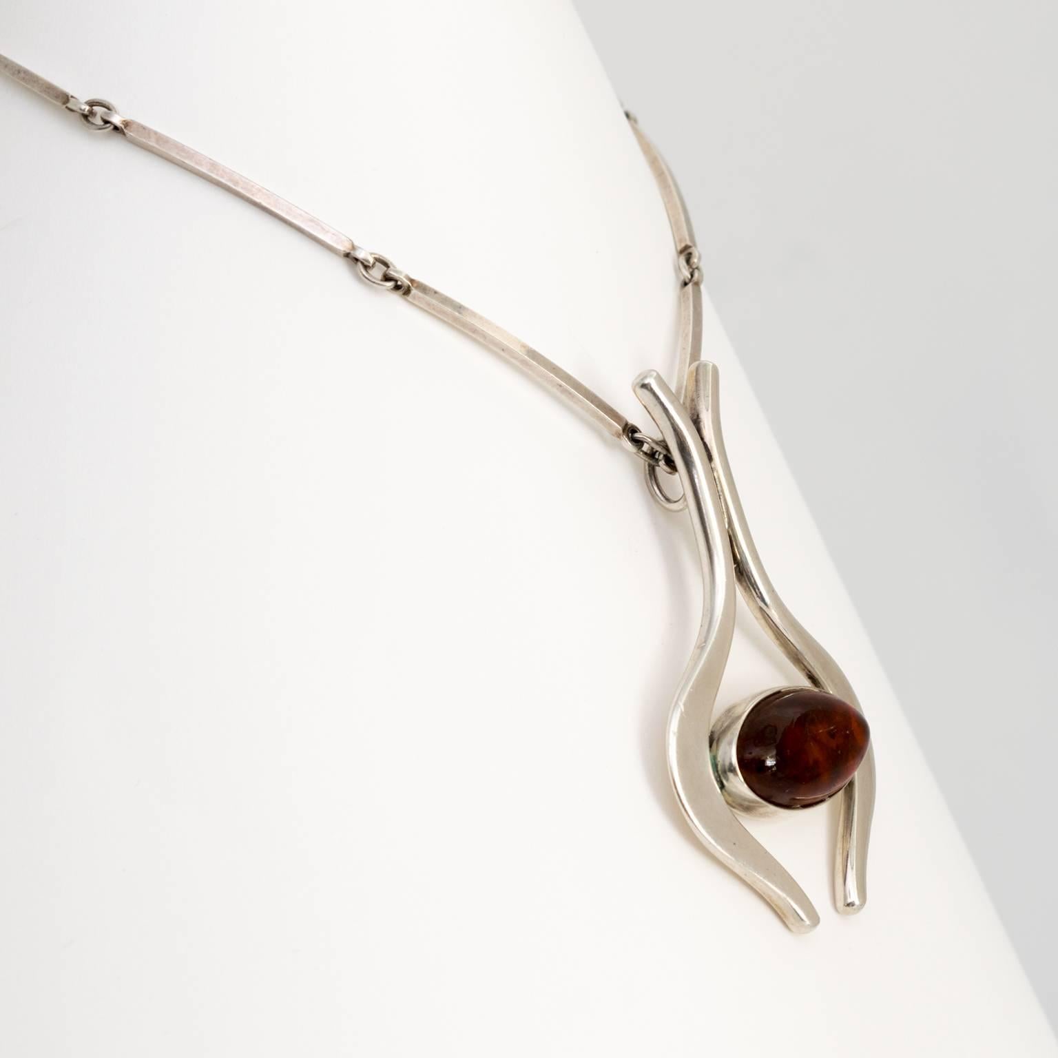 Scandinavian Modern Sterling silver necklace and pendant with cabochon in amber. Designed by Niels Erik From, Denmark, 1960s.
 
Total length: 12”, chain 10”, pendant 2.5”.
Pendant height: 2.75".