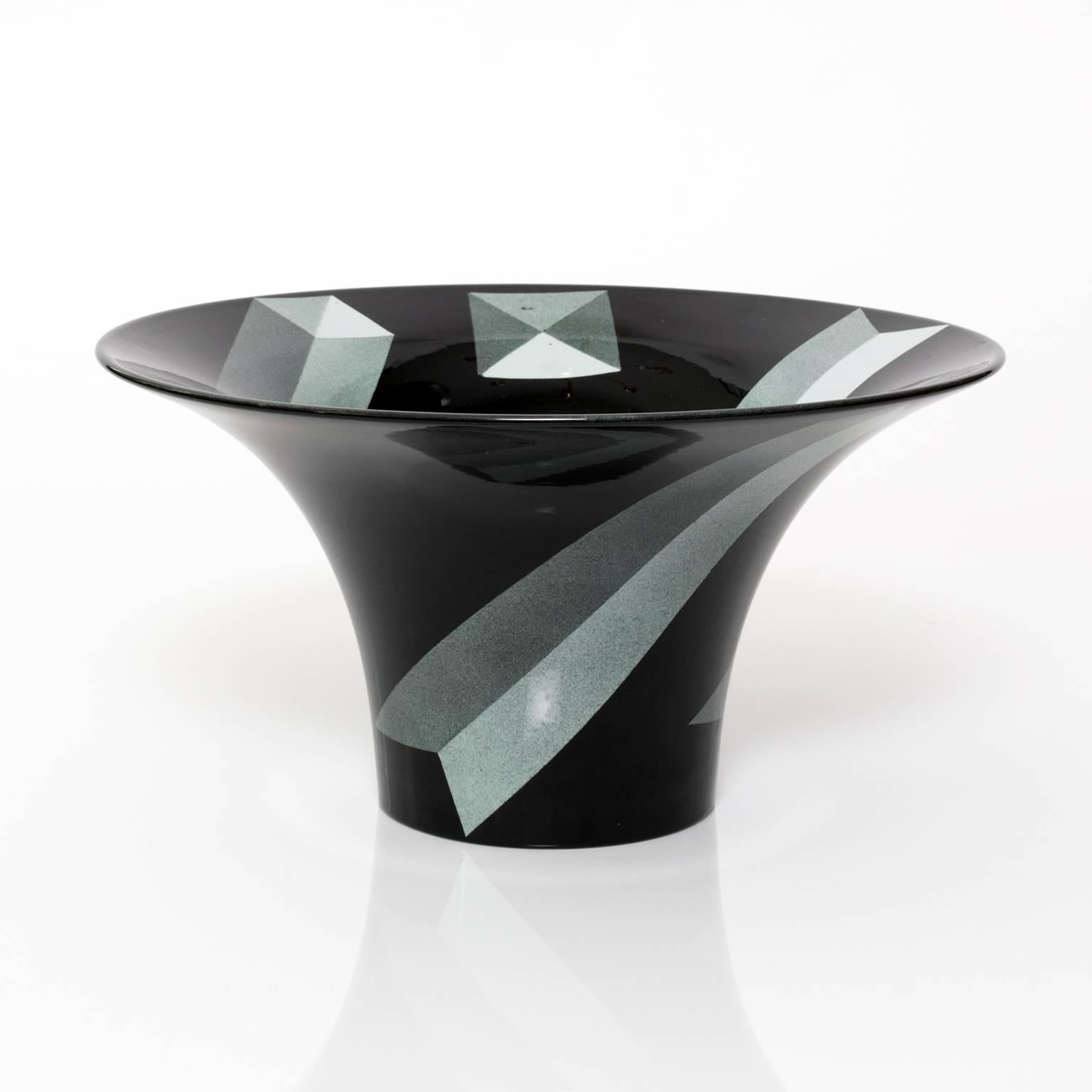 A large beautiful Scandinavian Modern, Postmodern porcelain bowl by Rolf Sinnemark for Rorstrand, Sweden. The black glazed bowl is decorated on the exterior and interior with depictions of obelisk forms.
 
Measures: Height: 6", diameter: