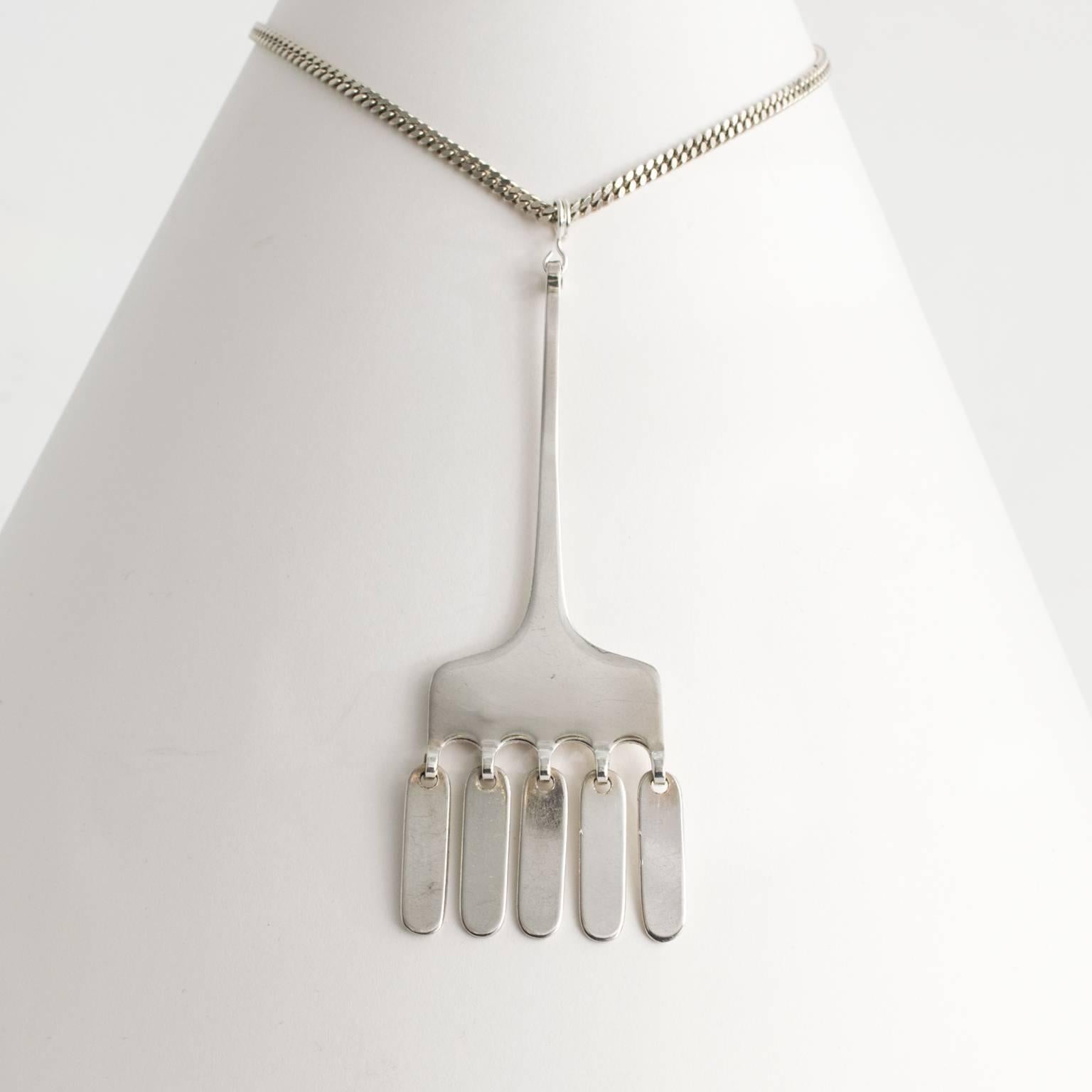 Silver Scandinavian Modern "MEMA" pendant with five capsule shaped elements on a silver chain. From Lidkoping, Sweden, 1972.
 
Chain length: 27"
Pendant height: 3".