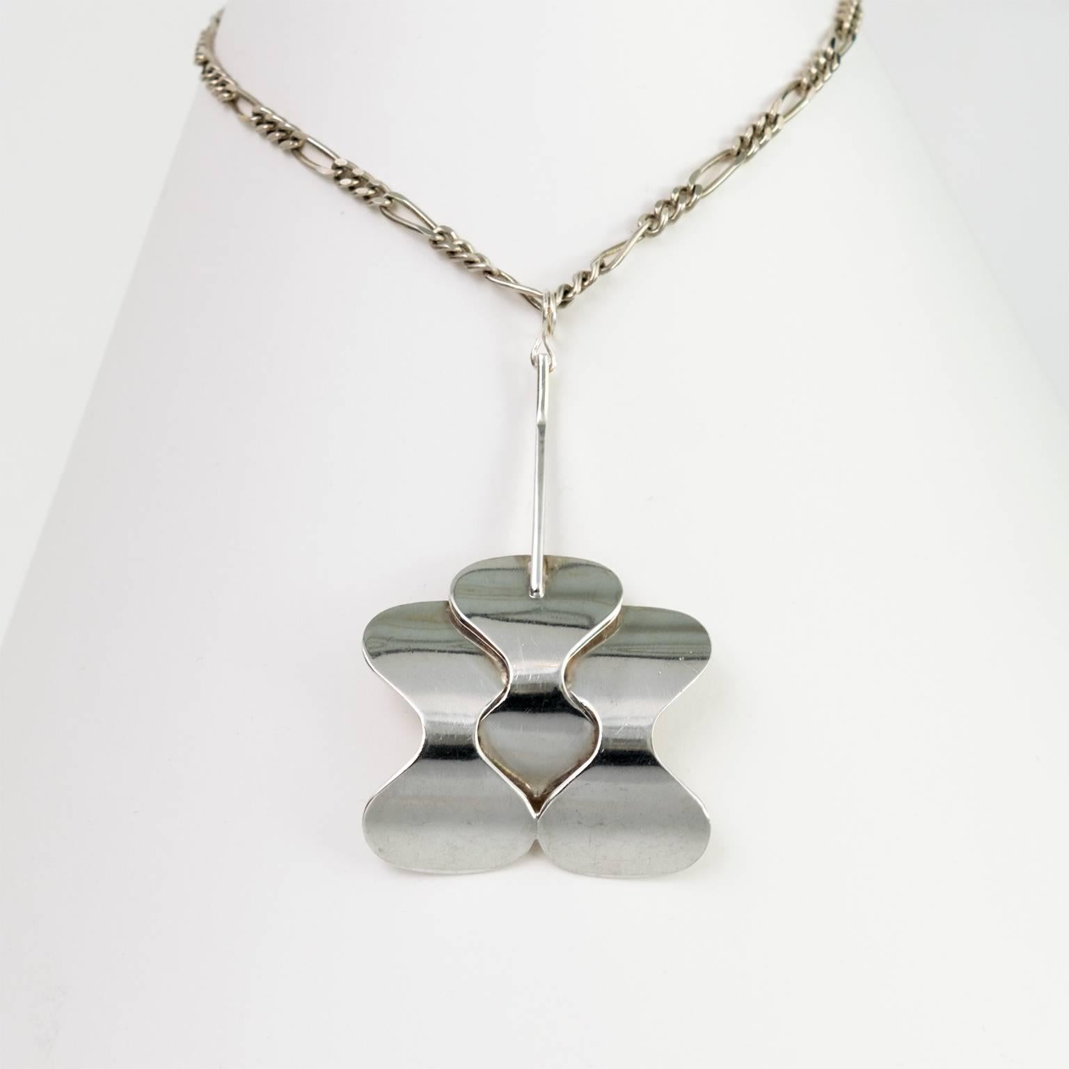 Silver Scandinavian Modern pendant with three soft curves shapes and silver chain from Hopeajaloste OY., Helsinki, Finland.
 
Chain length: 26".
Pendant height: 2.75".