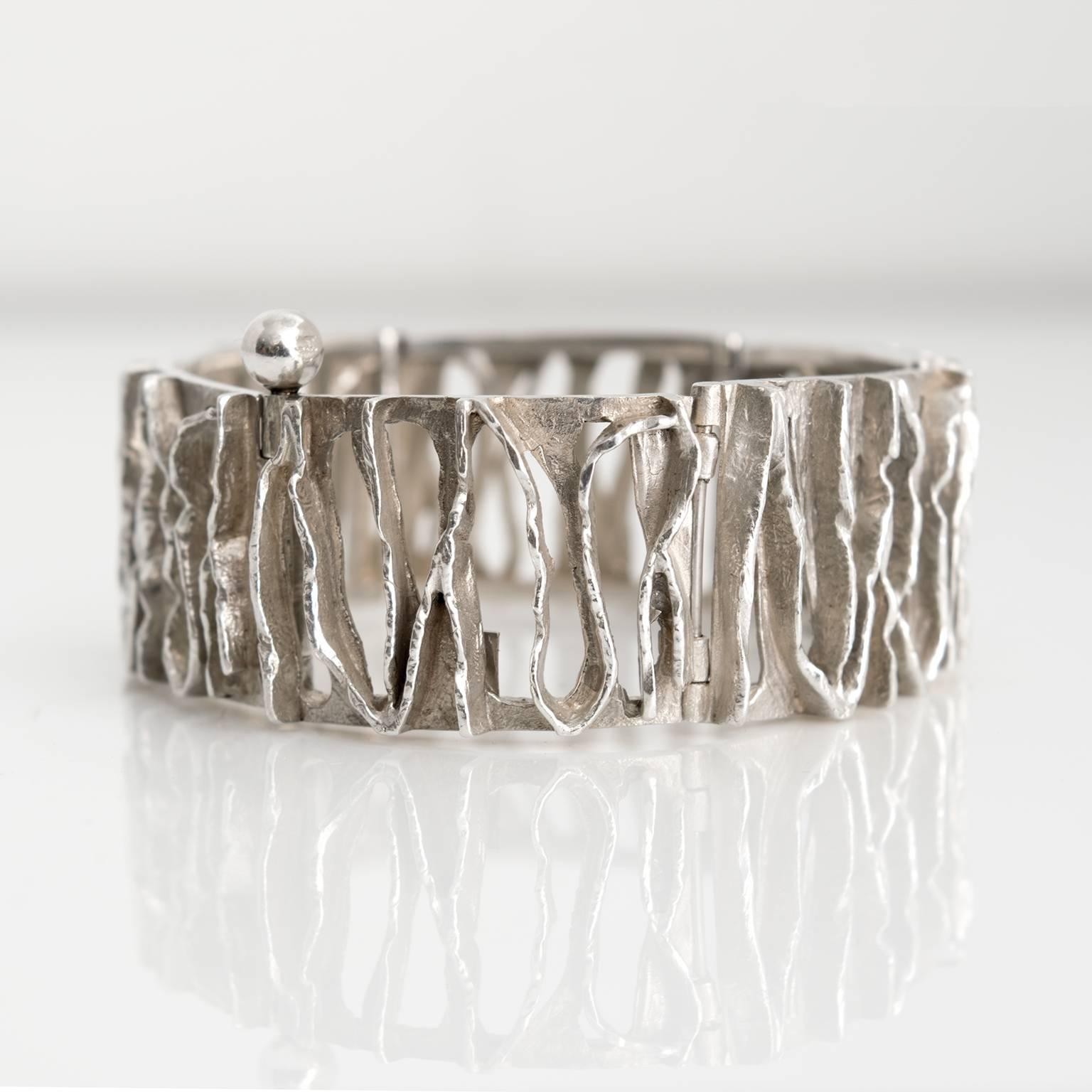 A Scandinavian Modern Silver bracelet with polished and etched openings from Denmark by C. Holm.
Measures: Diameter: 2.5".
Height: 1".