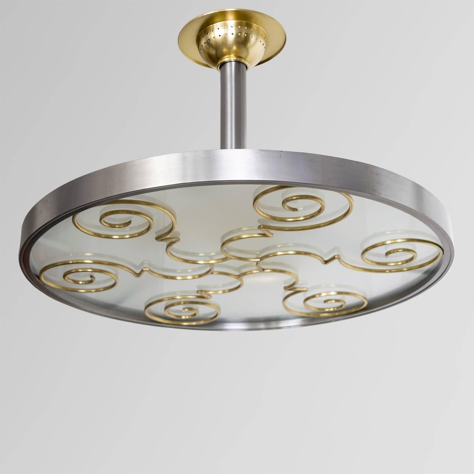 Scandinavian modern steel, brass and glass pendant fixture designed by Lars Holmstrom (with impressed mark). The fixture's polished steel frame holds a brass grille with six spirals below an acid etched original glass diffuser. Three painted iron