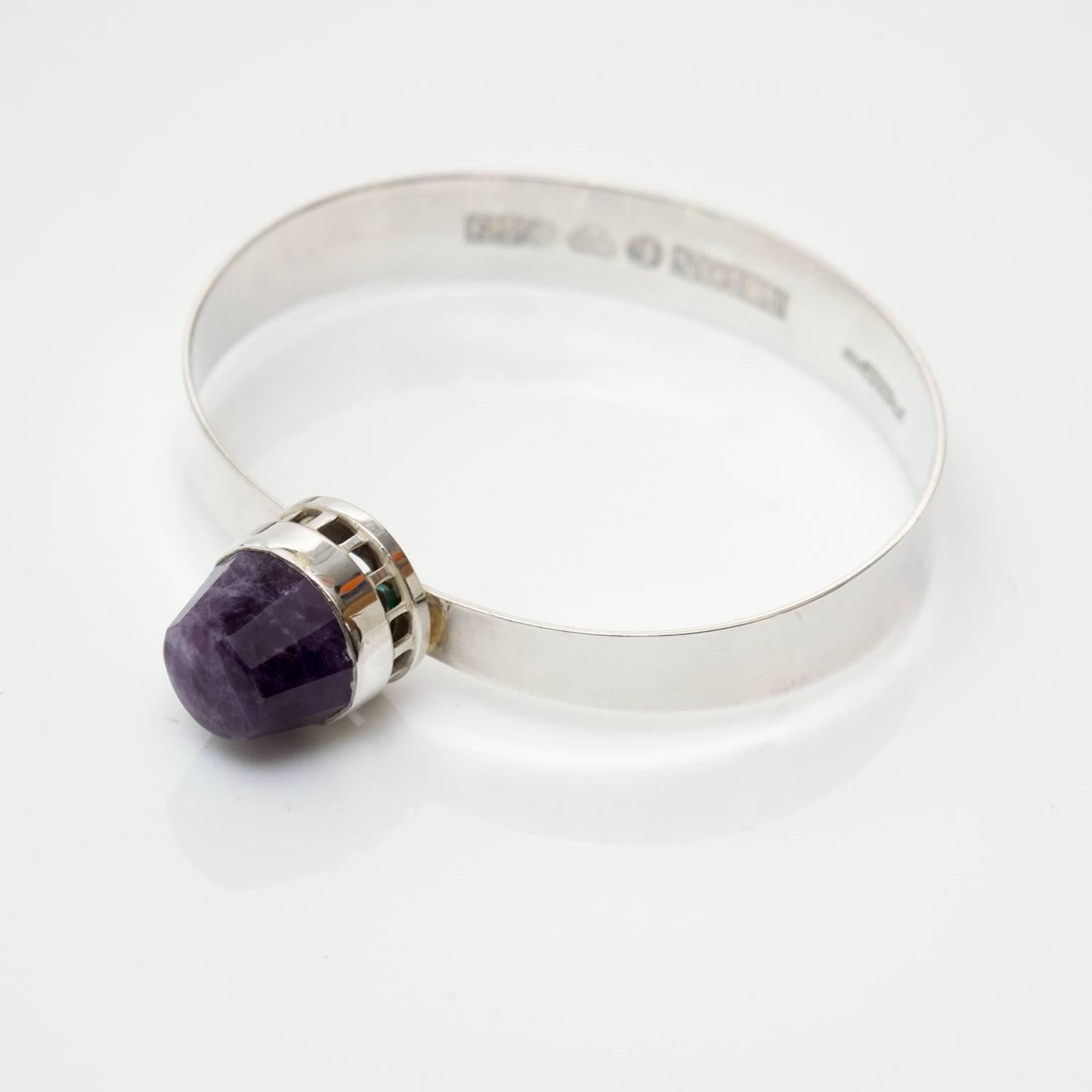 Scandinavian Modern, Sterling silver bracelet with a faceted purple colored gemstone. Designer stamped "Pege" Alton, made in Sweden, 1969.
Diameter: 2.5
Height: 3.25' ".