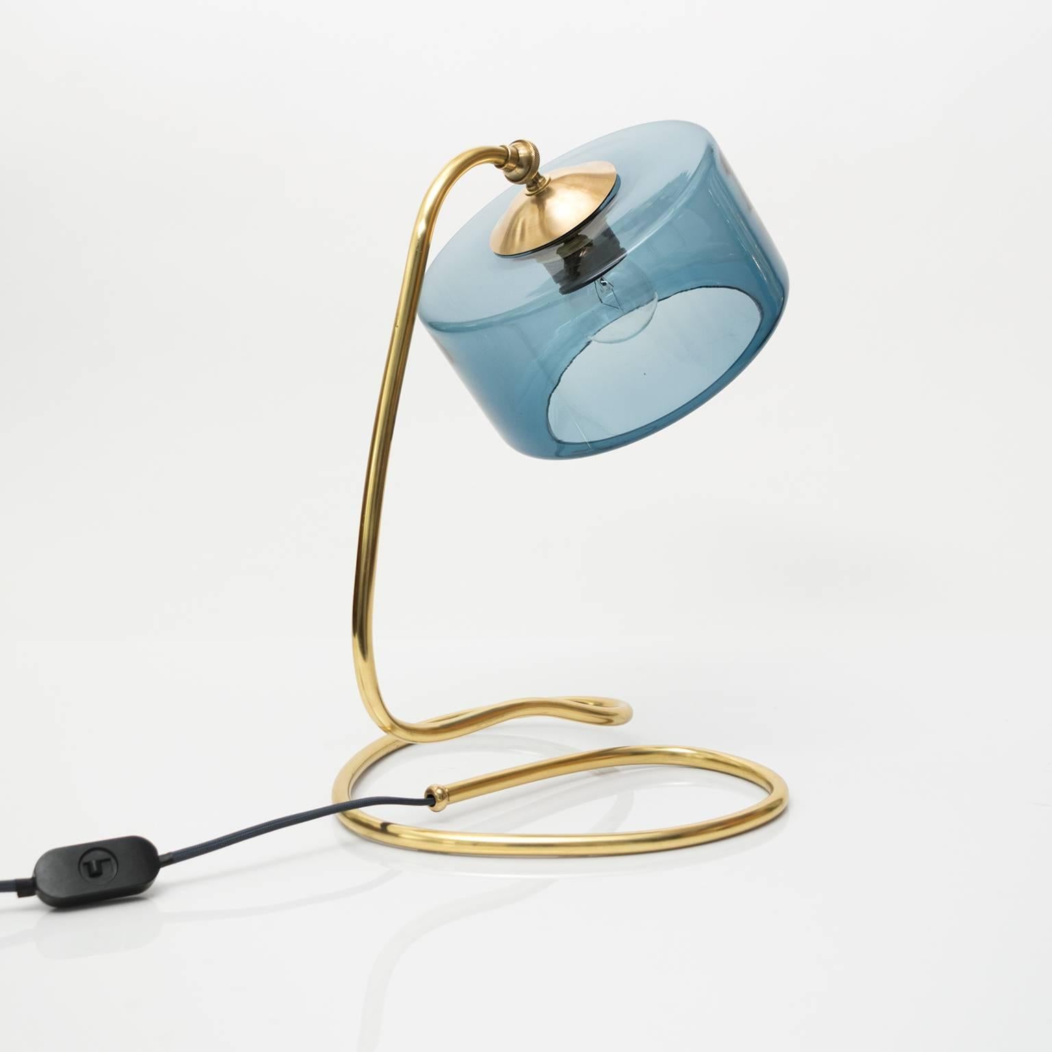 Scandinavian modern table lamp with a polished coil base and clear blue glass shade. Newly restored polished and lacquered brass and wired with a single standard base socket.
Measures: Height: 14
