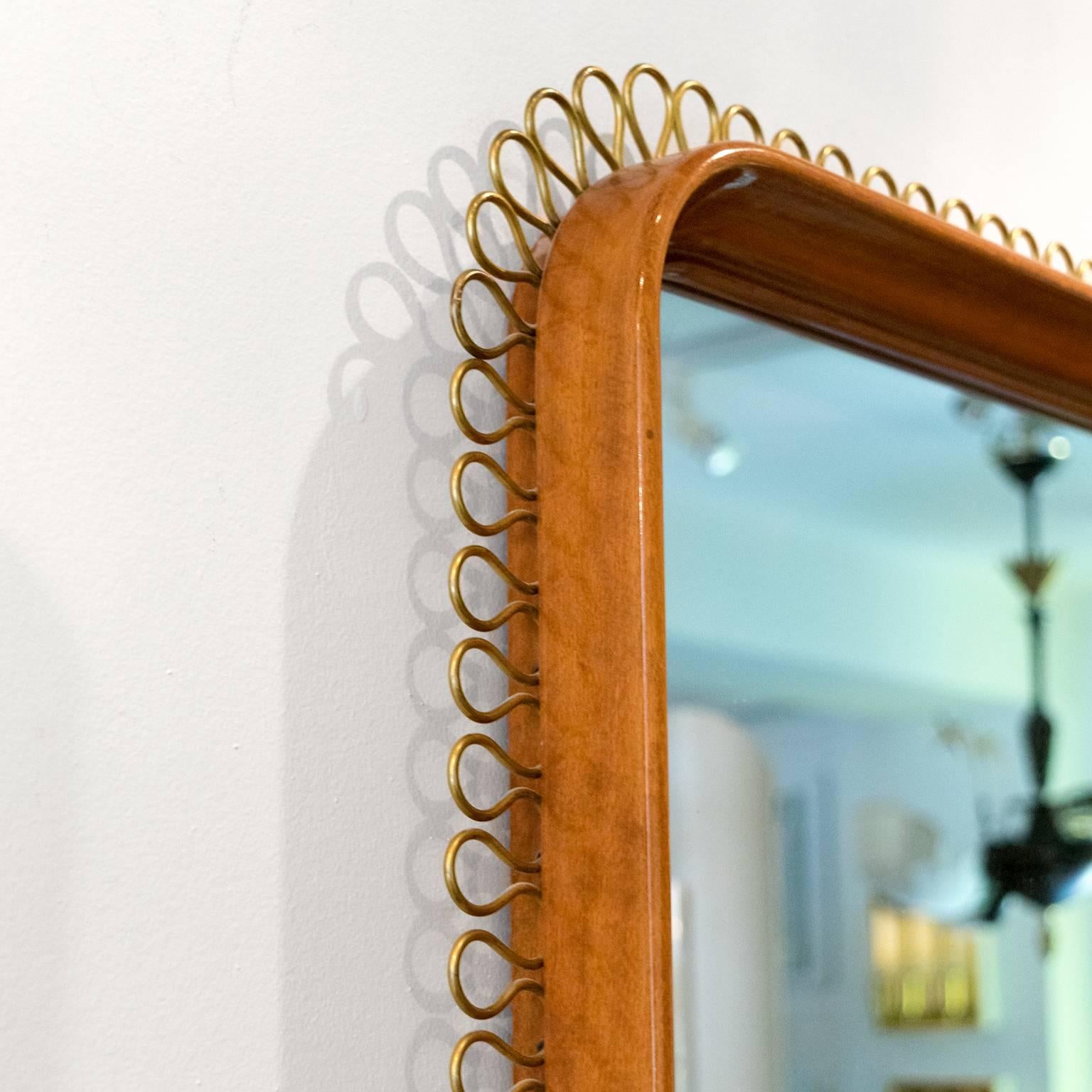 Scandinavian Modern solid mahogany mirror with rounded corners and decorated with an exterior bent brass border. Made by NK (Nordiska Kompaniet) Stockholm, Sweden.
 
Measures: Height 31.5
