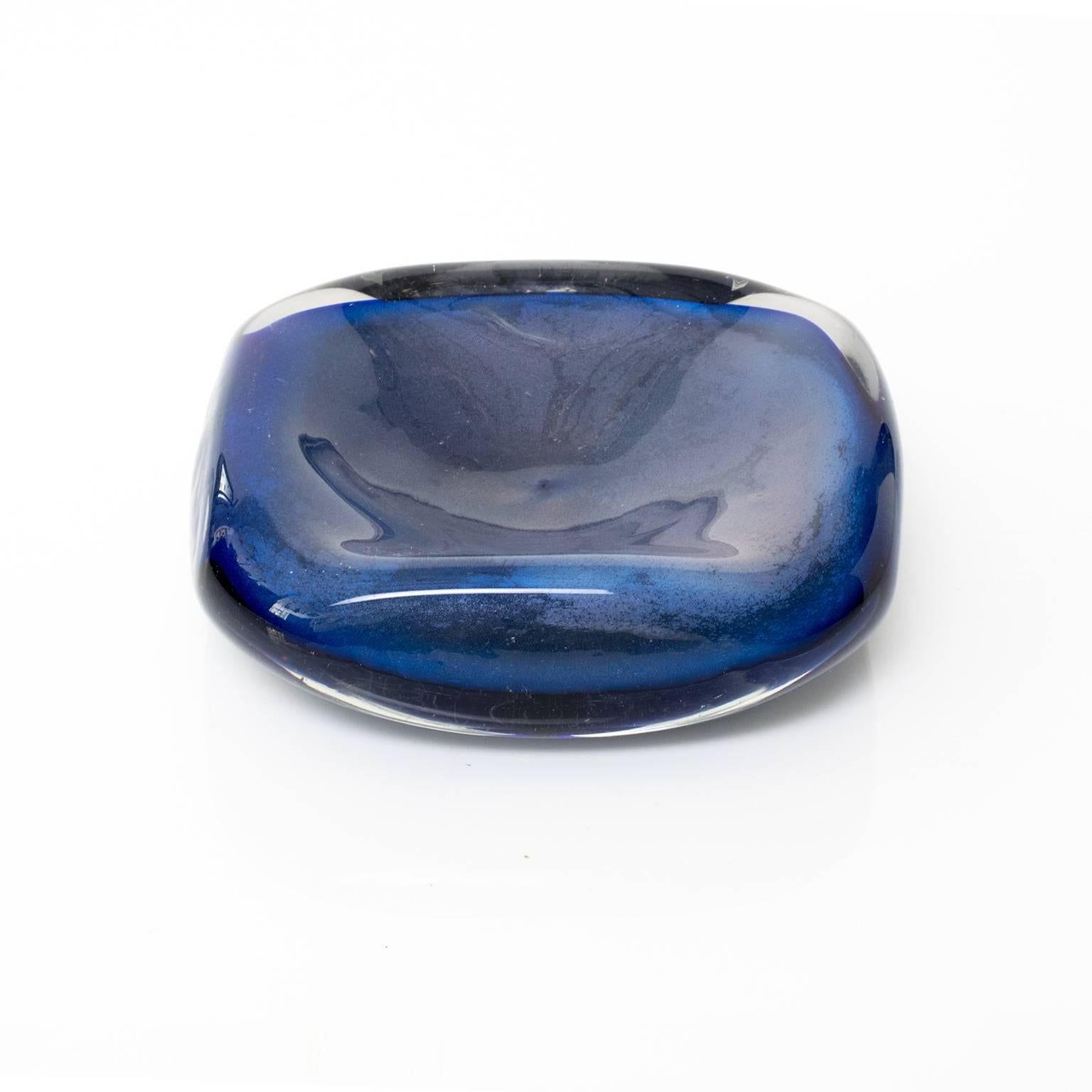 Small hand-forged blue glass bowl encased in a clear glass layer. Made in Sweden, circa 1960.
 
Measure: Height 2