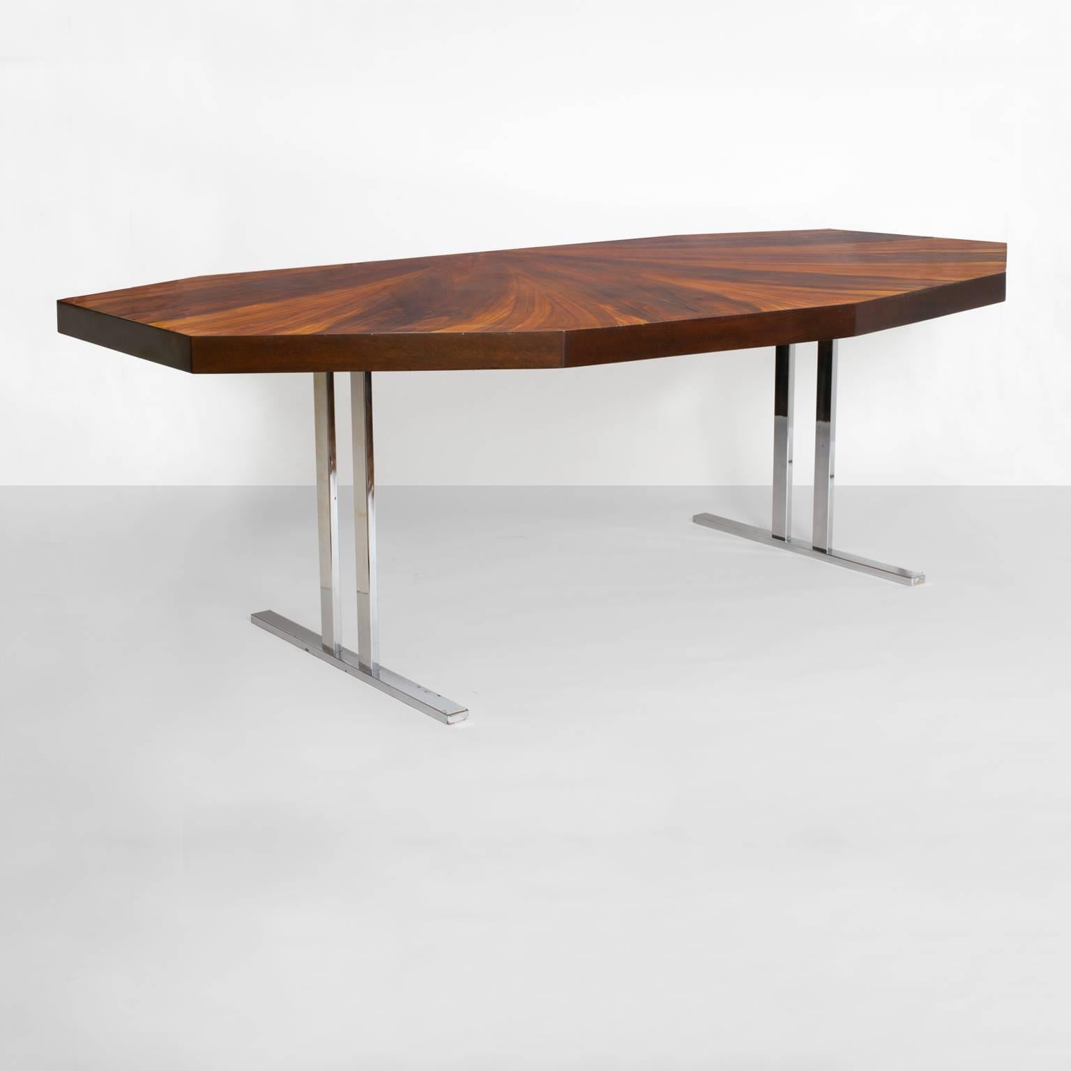 A Scandinavian Modern dining table or desk with chromed steel legs. The table has (nine) sides set at various angles and features a dramatic fan pattern in Rosewood veneer. Newly restored top in excellent condition, chrome base has some small