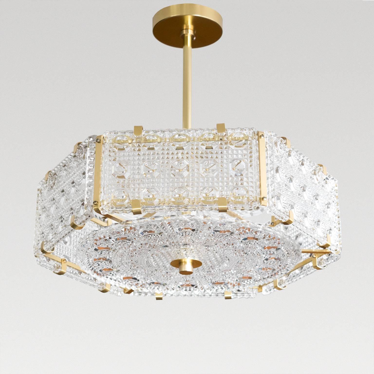 A Mid-Century Modern hexagonal shaped polished crystal pendant with rectangular sides and disc at top and bottom. The fixture has newly polished and lacquered hardware, frame, stem and canopy. Newly rewired for use in the USA with three candelabra