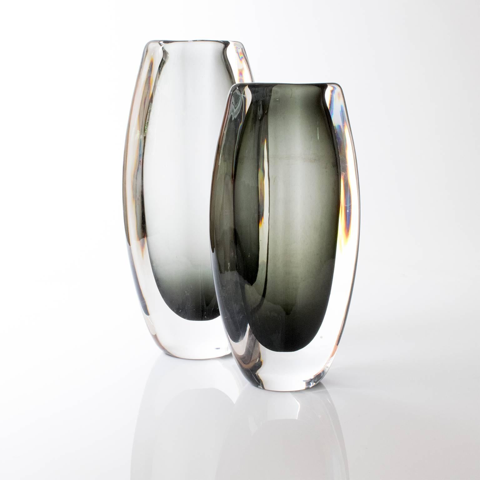 Two large hand-forged clear and neutral green mid-century modern glass vases. Designed by Nils Landberg for Orrefors, made in Sweden, circa 1960. The smaller vase a mineral trace marks.
 
Measures: Height 2