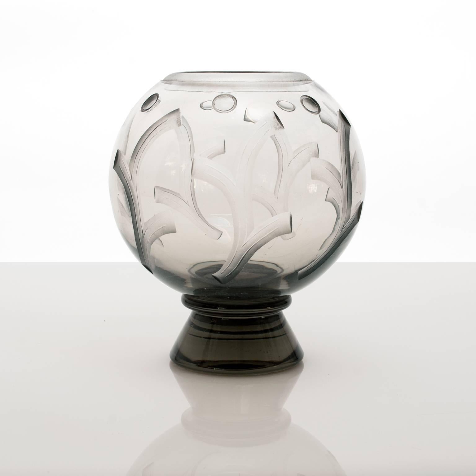 Scandinavian Modern Art Deco glass vase with etched design of stylized tree branches and circles. The vase is on a cone shaped foot in a transparent smokey ash colored glass. Designed by Simon Gate for Orrefors, dated 31. Minor wear.