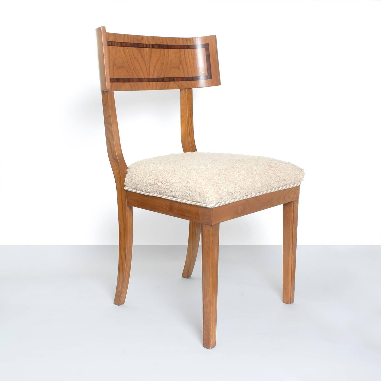 Set of six Scandinavian Modern dining chairs in the Klismos model. Each chair is constructed of solid elmwood with elm and palisander veneer on the backrest. Fully restored and upholstered with faux lamps skin fabric,
Measures: Height 34.25