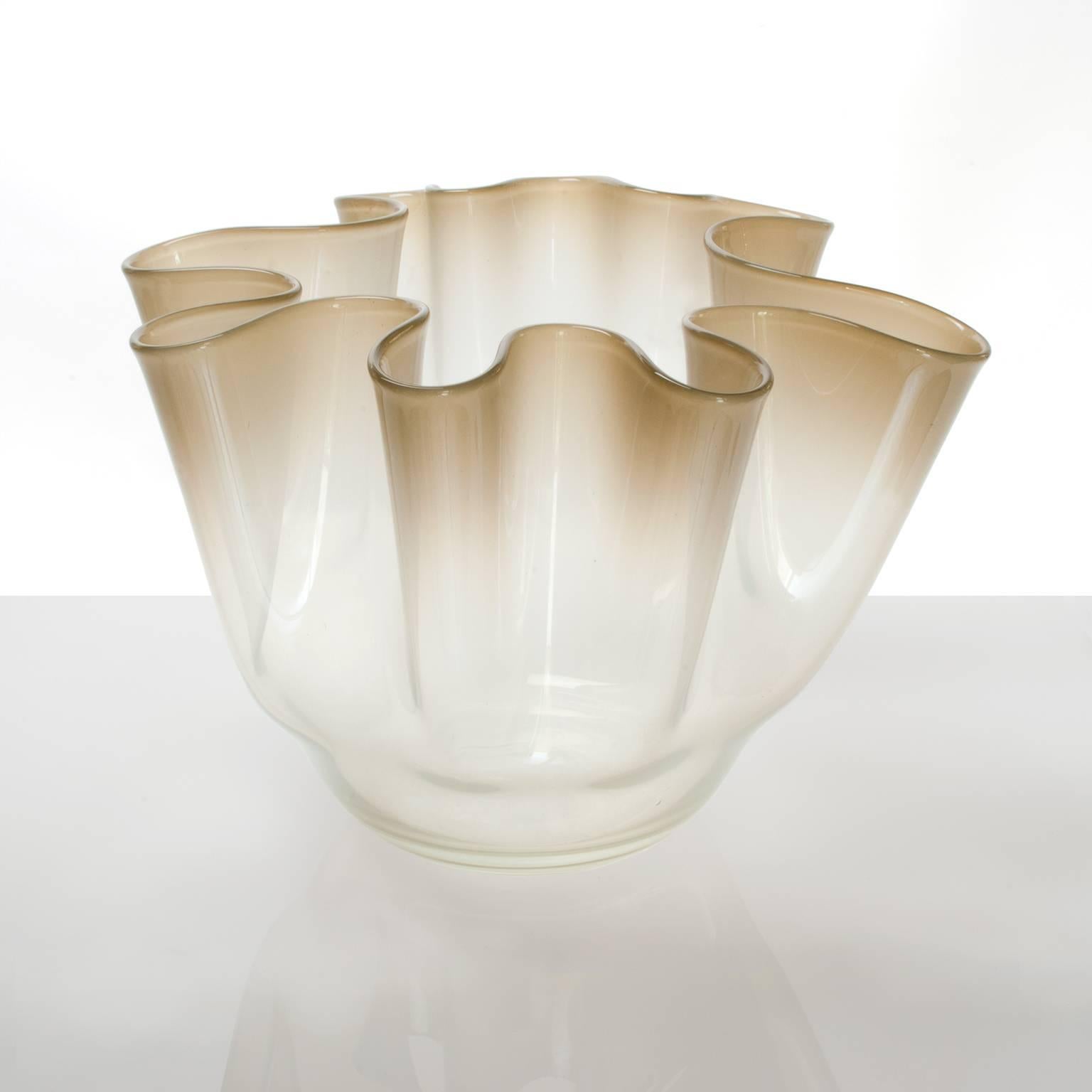 A large Danish Mid-Century Modern bowl / vase by Kylle Svanlund for Holmgaard Glasværk, circa 1960s. The piece features a softly folded form in clear to pale gold color glass. Marked on bottom.
Measures: Height 10