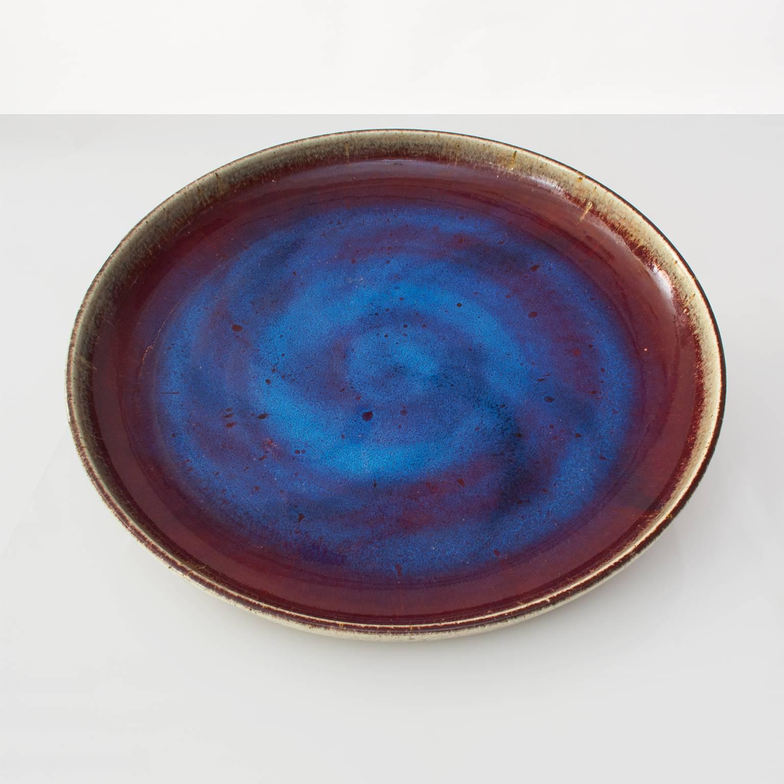 A very large Scandinavian Modern midcentury Rorstrand studio bowl or platter by Bertil Lindgren with oxblood and a brilliant sapphire blue glaze. Signed on the bottom as well as numbered "97 / 100". Diameter: 21", Height: 3"