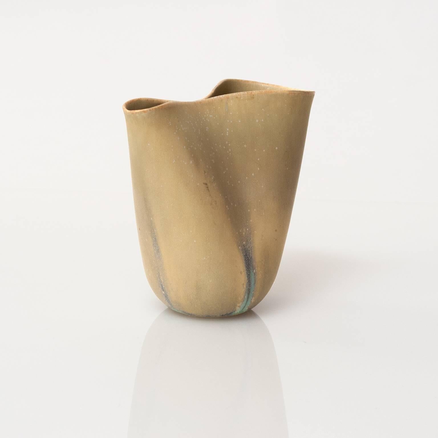 A rare golden glazed "Veckla" vase by famed ceramicist artist Stig Lindberg. The  vase has a soft form shape and a pinched center. The Veckla line by Lindberg was done primary in a matt white glazed. The mottled glaze has areas of light