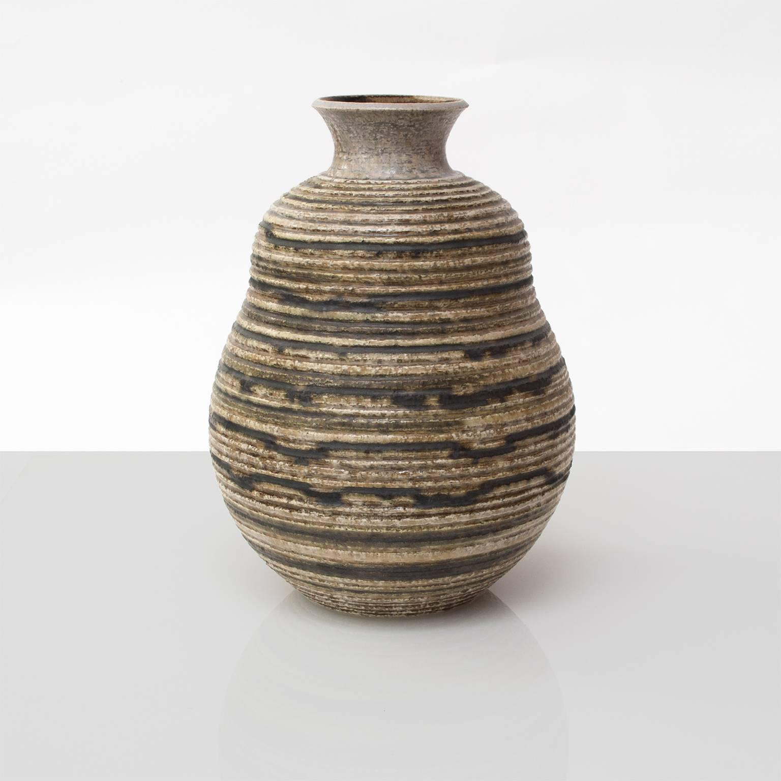 A large Scandinavian modern studio vase by Britt-Louise Sundell for Gustavsberg circa 1960. Vase is highly textured with horizontal groves and glazed in earthy, nuetral colors. 
Height: 12