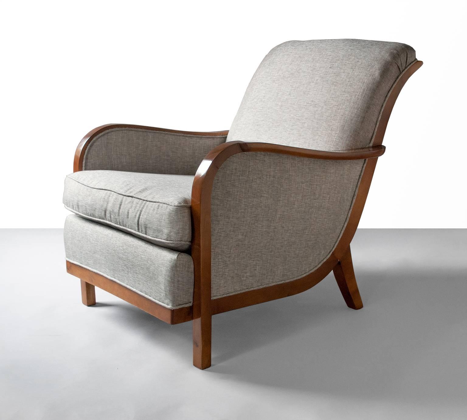Elegant Swedish art deco armchair with a graceful scrolled back raised on sabre back legs. The chair is solid stained birch and features a cantilevered platform seat with upholstered cushion. Produced by Wilhelm Knoll, Malmo, 1933. Newly refinished