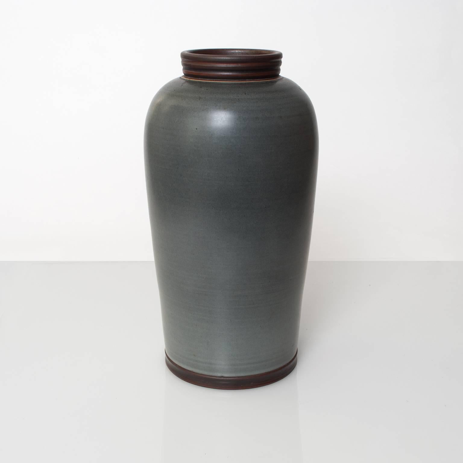 A Swedish art deco, unique studio ceramic vase from artist Gunnar Nylund for ALP, Lidkoping. Finished in a dark gray blue glaze and detailed in a brown glaze with touches of gold. 
Height: 13