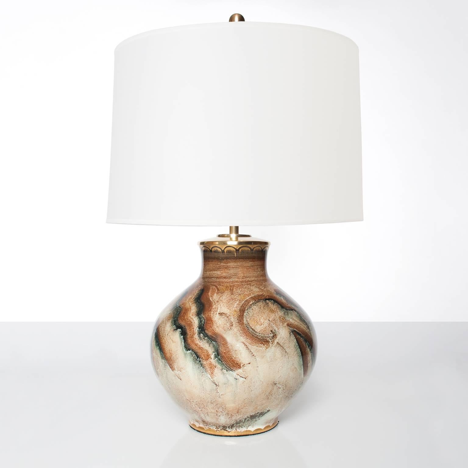 Scandinavian Modern, Swedish art deco ceramic table lamp with hand decoration with a luster glaze and detailed in gold. Made at Gustavsberg circa 1930. Hardware in polished brass, newly electrified with polished and lacquered brass double socket