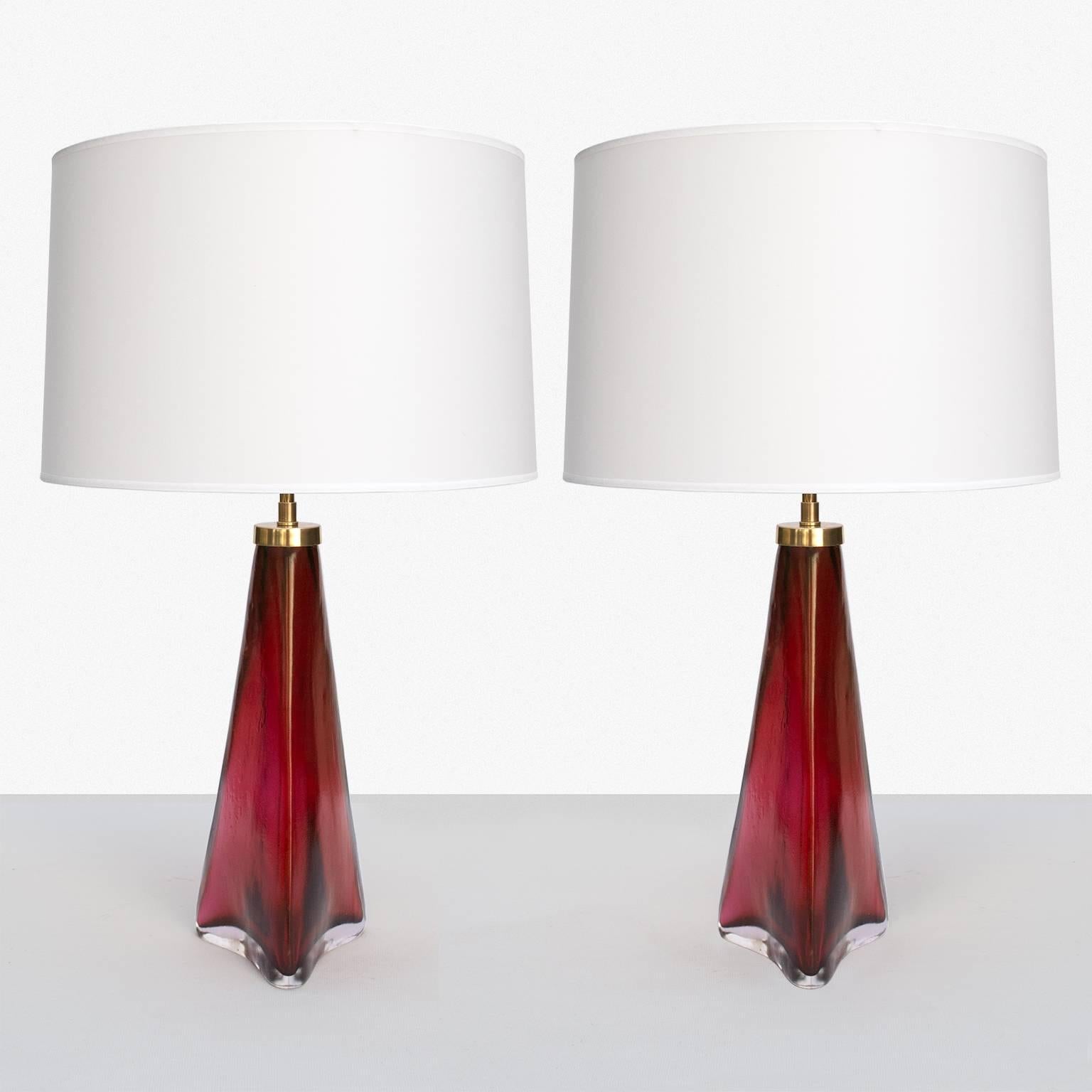 Gorgeous pair of Swedish table lamps in red and clear glass with matt, acid treated finish. Signed Orrefors on the brass cap, lamps retains original paper label. Wired for the US with new high-end double cluster socket hardware of polished lacquered