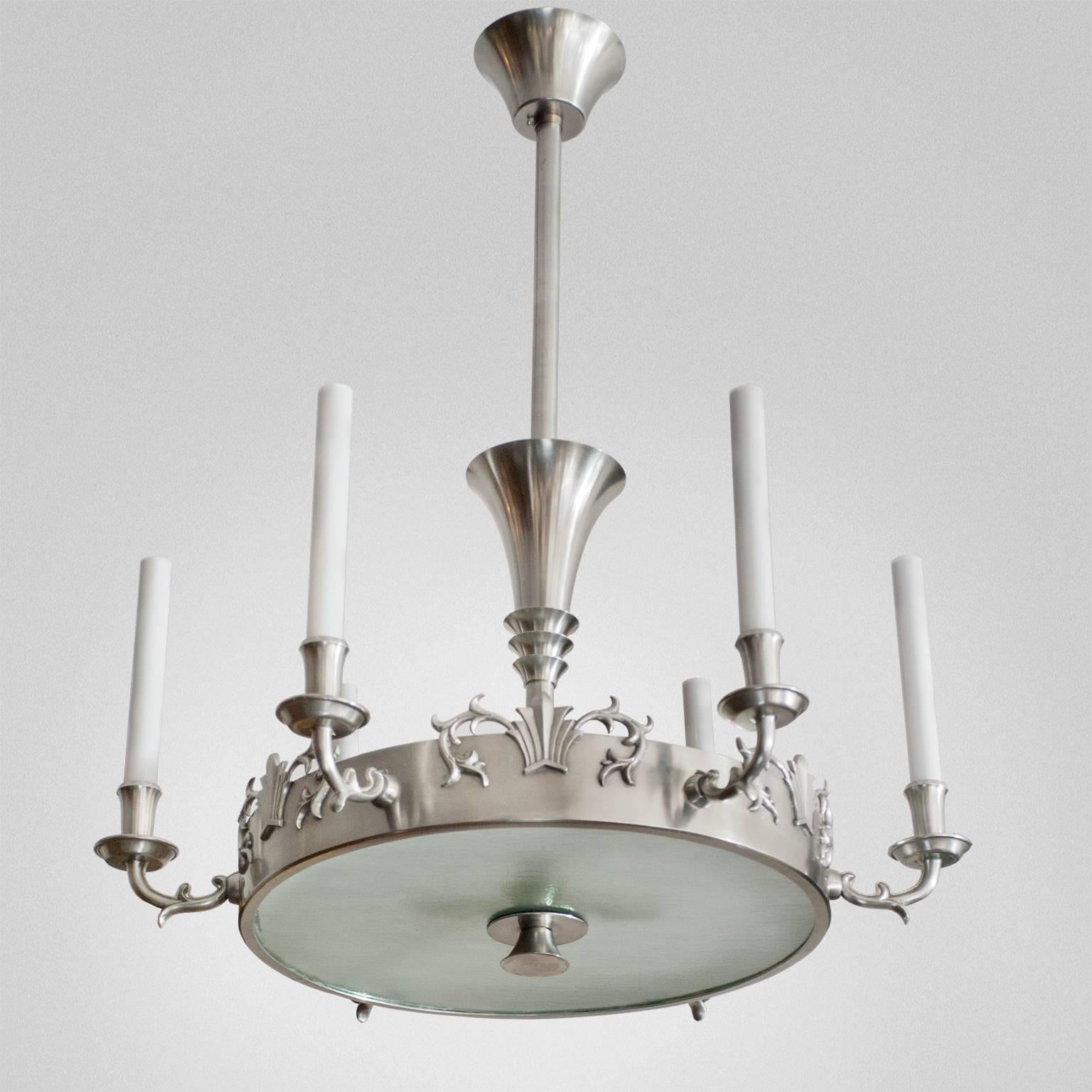 Elegant Swedish Art Deco solid pewter 6-arm chandelier by Carl Tingstrom. Ring form with applied stylized decorations. The center houses 4 standard socket, each arm uses candelabra base sockets. Newly polished, lacquered and rewired, original glass