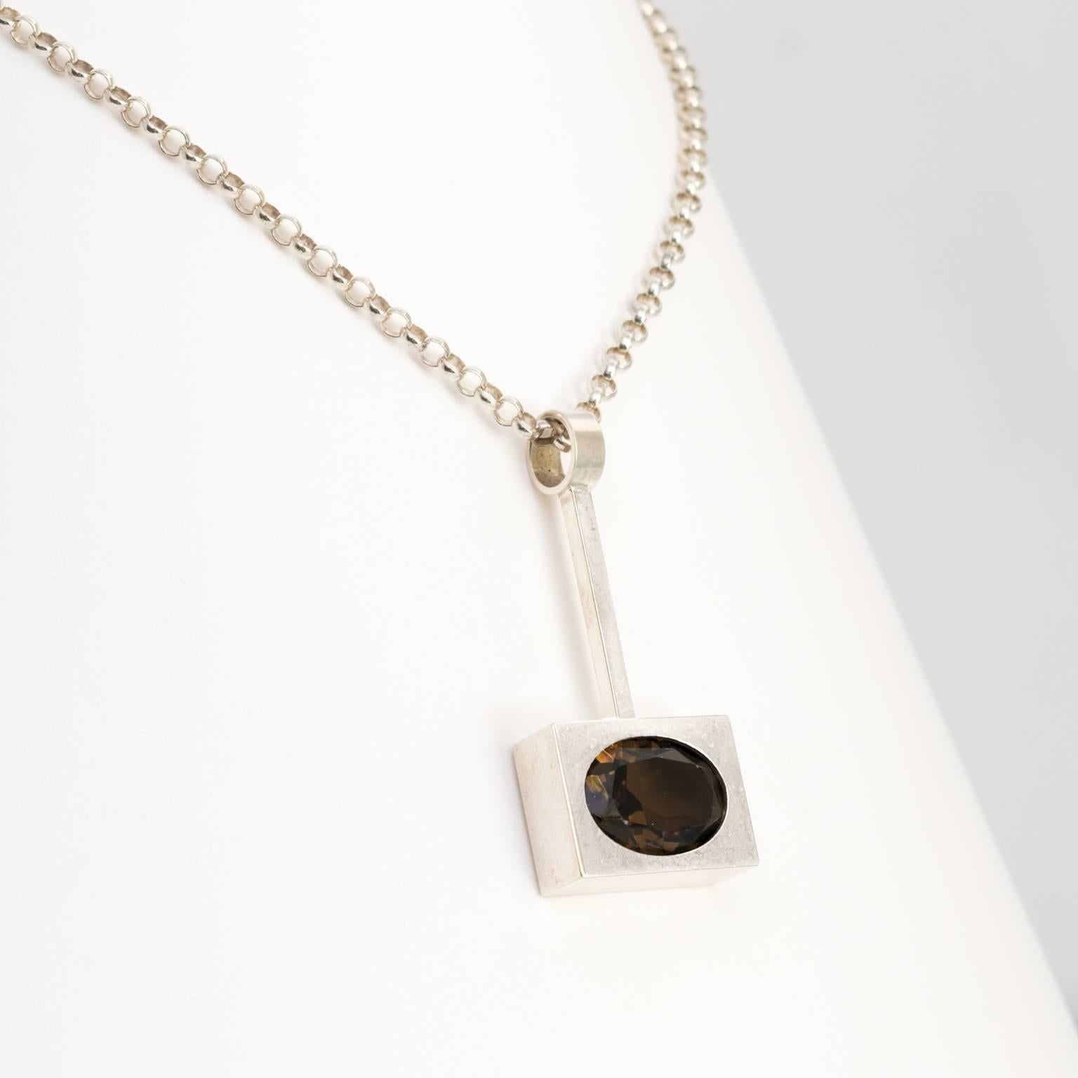 Silver Scandinavian modern pendant with an inserted oval faceted smoky quartz stone. The chain is also silver. Designed by Kupitaan Kulta, Finland. 
 
Measures: Chain length: 16".
Pendant height: 2".
