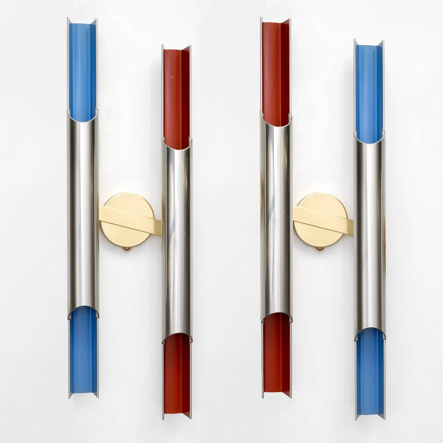 A pair of double arm Scandinavian Modern sconces in polished aluminum with red and blue lacquer. Designed by Bent Karlby for Lyfa, Denmark, 1968. The tubular forms hold two candelabra base bulbs per arm. The angled brass backplates are original.