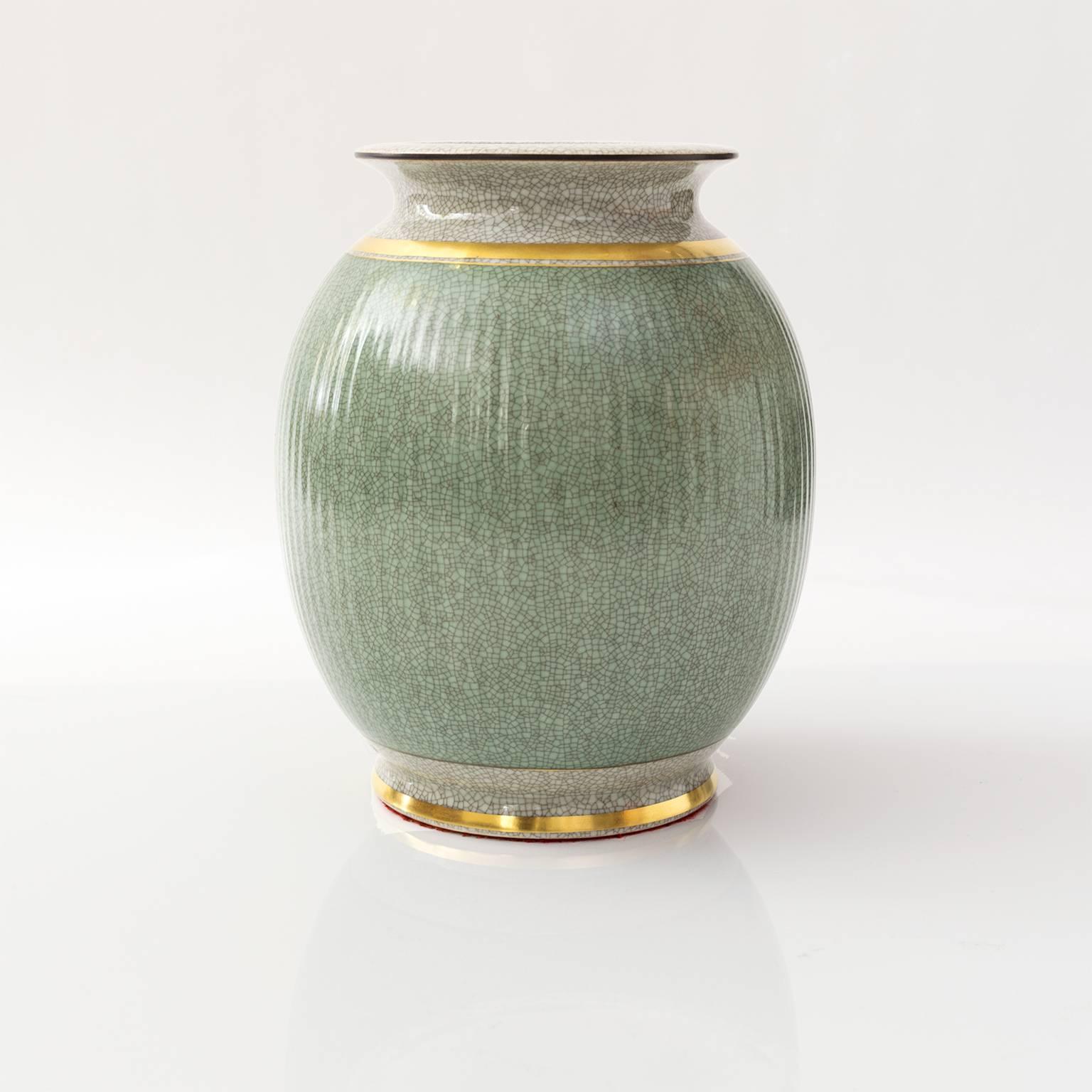 Scandinavian modern large Royal Copenhagen ceramic vase in green and white (craquelure) crackle glaze and detailed in gold. Made in Denmark, circa 1940s.
 
Measures: Height 9.75