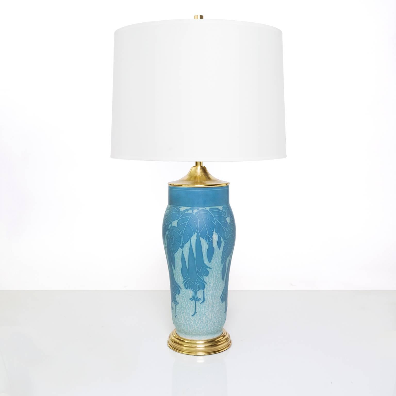 A Scandinavian Modern, Swedish Art Deco table lamp in ceramic "Sgraffito" technique with a floral vine motif. The lamp retains its original polished brass foot and cap which has been polished and lacquered. Newly rewired with a polished