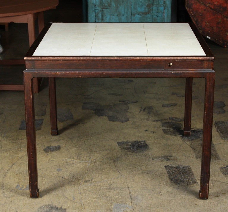 Dark walnut games table made by Dunbar with white leather top and pocket drawers.