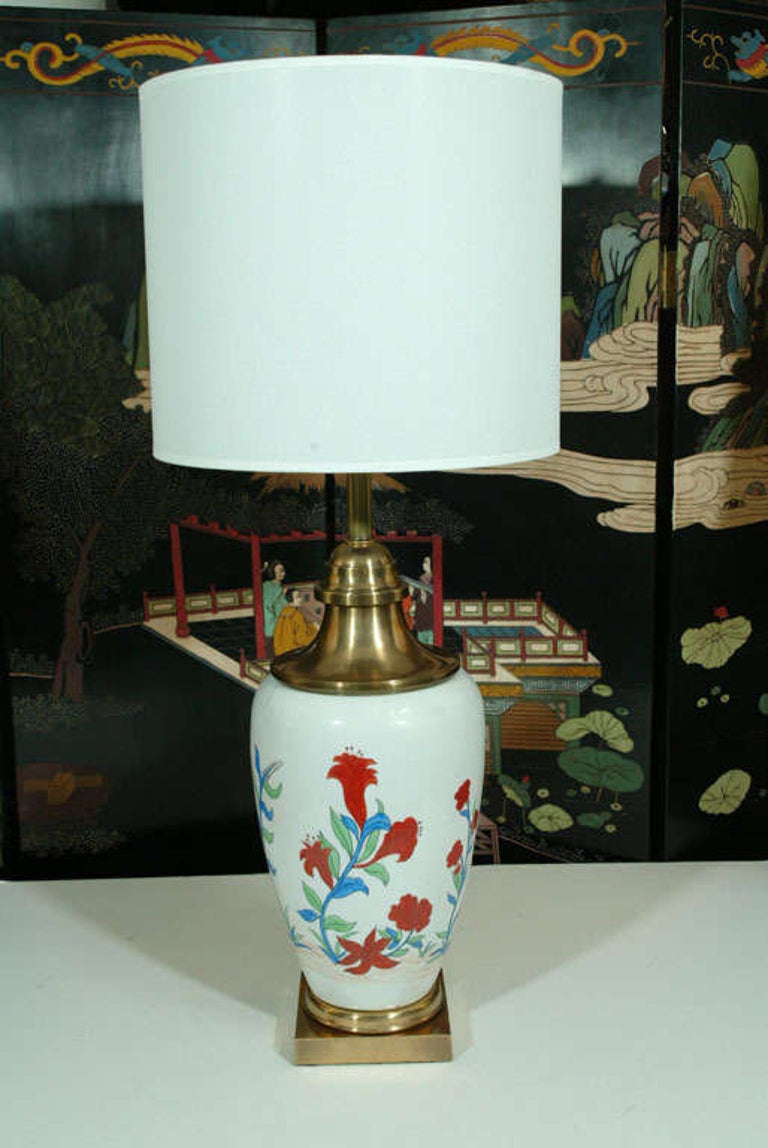 Pair of ginger jar shaped, hand painted floral porcelain lamps on heavy brass bases with adjustable double pull chain sockets. Rewired for use in the USA. Shades not included.