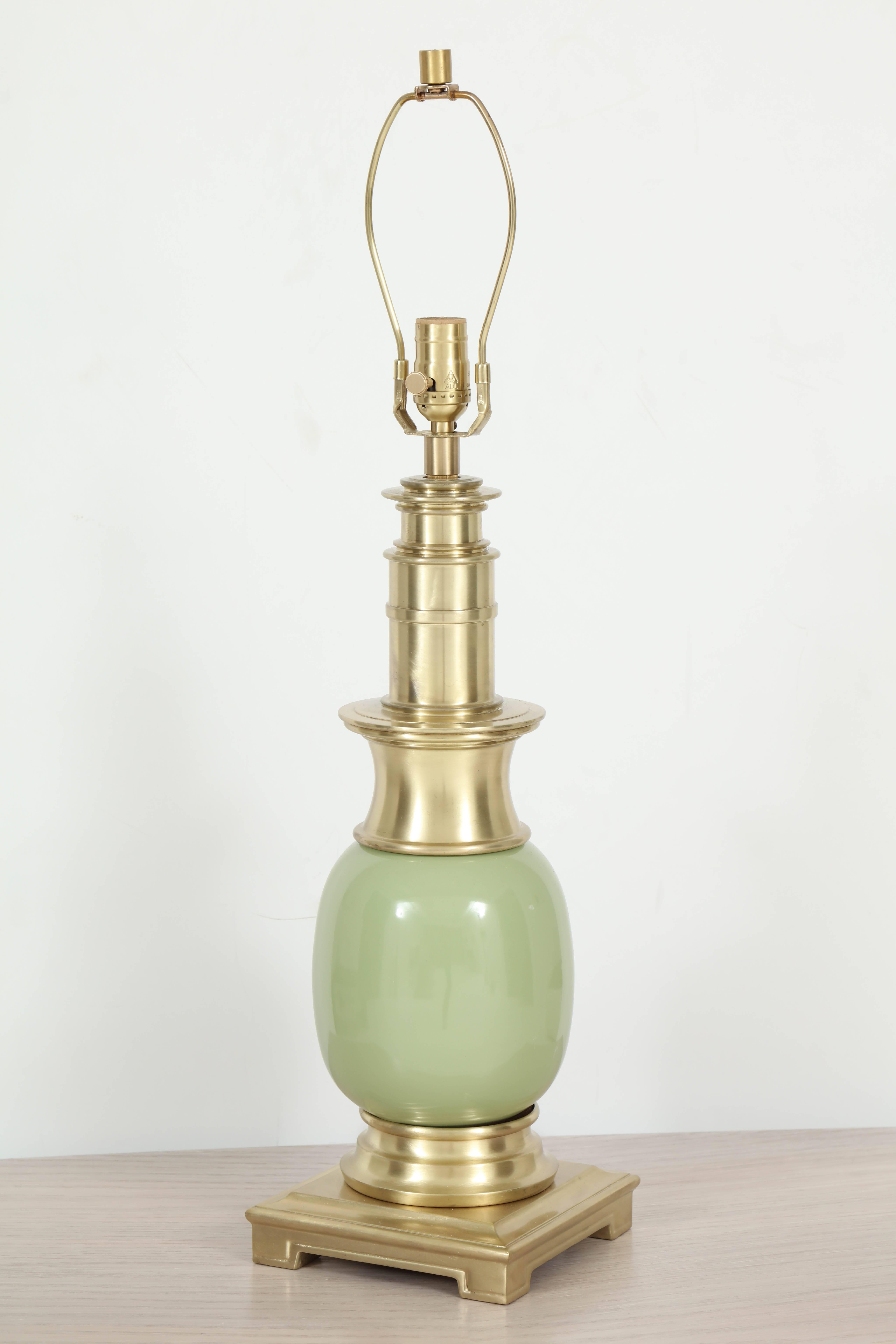 Pair of exquisite Parzinger influenced midcentury lamps with a muted celadon green ceramic orb body with satin brass fittings. Lamps have been rewired with new sockets and silk cords.