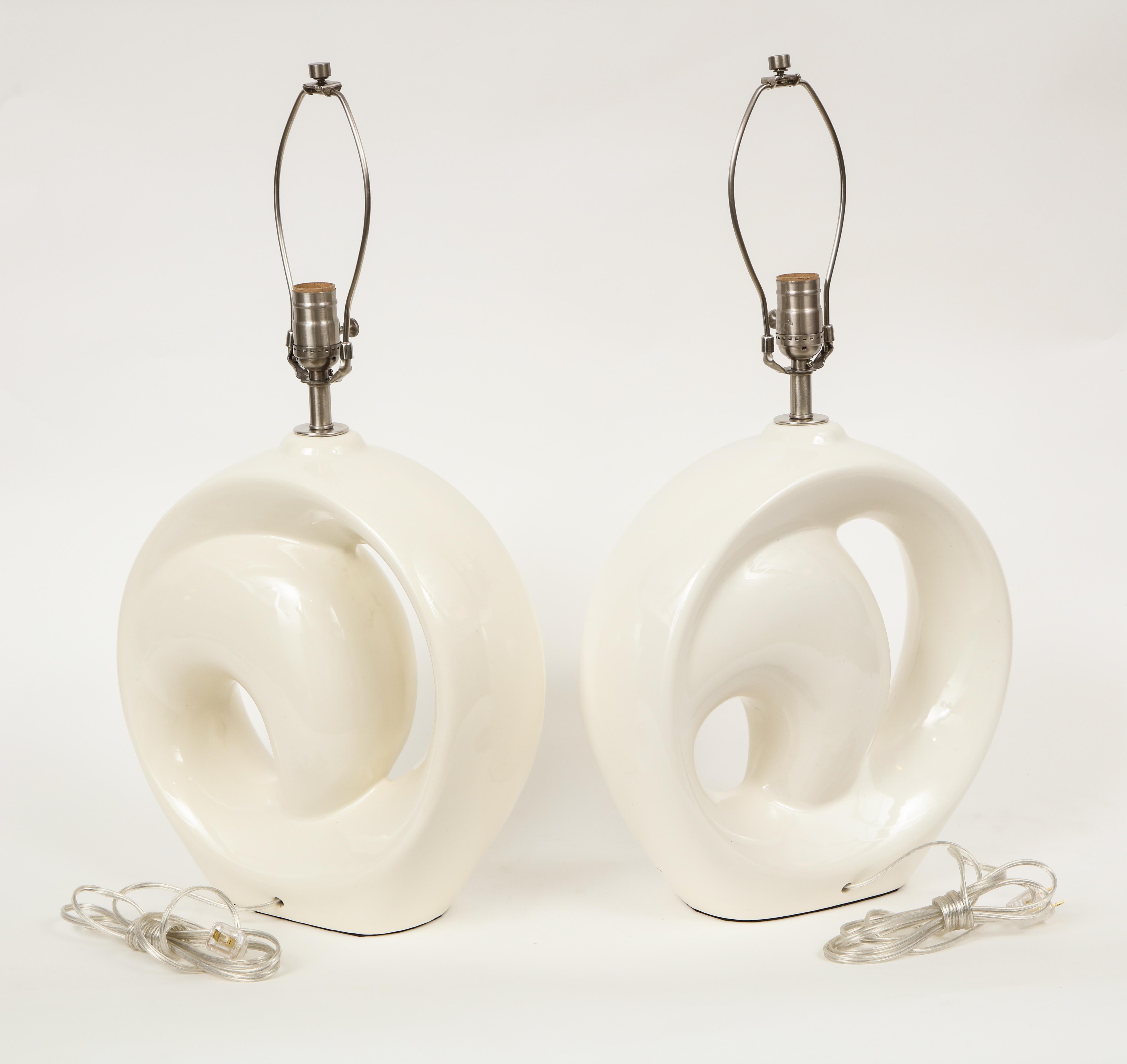 Pair of modernist porcelain lamps featuring a milky white glaze, and nickel hardware. Rewired for use in the USA. 100W bulb max.
