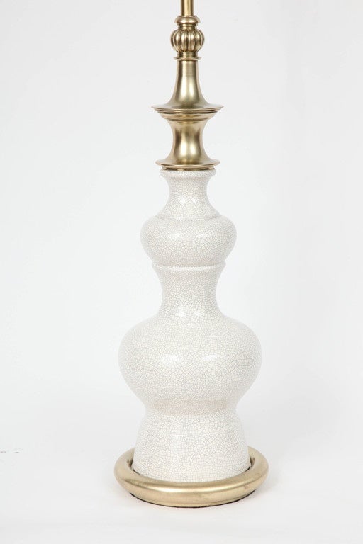 Fantastic pair of stylized pagoda form ceramic lamps in an off white crackle glaze and satin brass details. Lamps have been rewired with gold silk cords and new brass sockets.