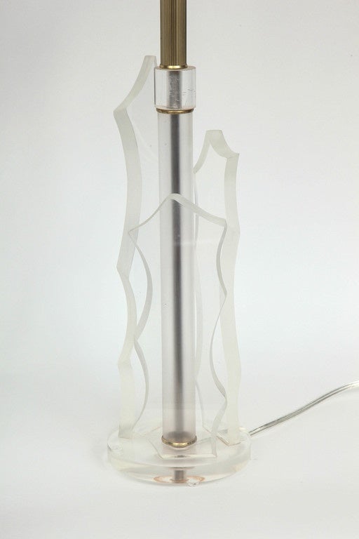 Fantastic pair of chic Lucite lamps made of four beveled edge sculptural Lucite slabs on a circular Lucite base. Lamps have been rewired with new clear cords and feature brass sockets.