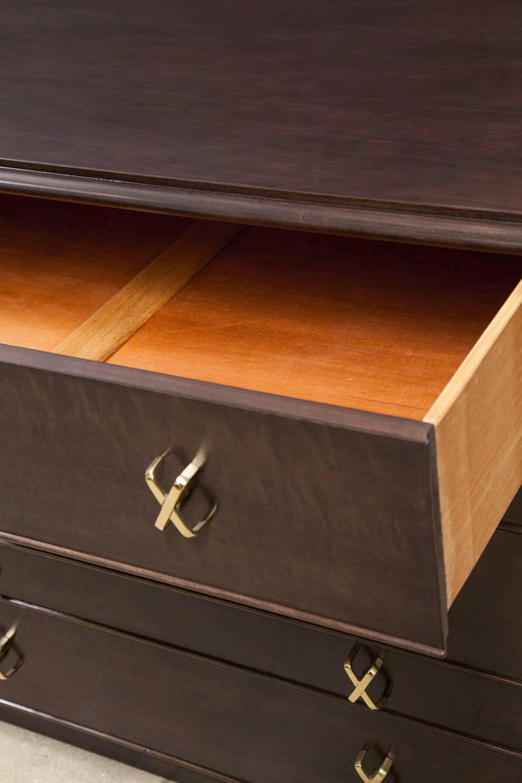 Mid-Century Classic chest of drawers in a rich brown stained walnut with a satin finish and polished brass X pulls.