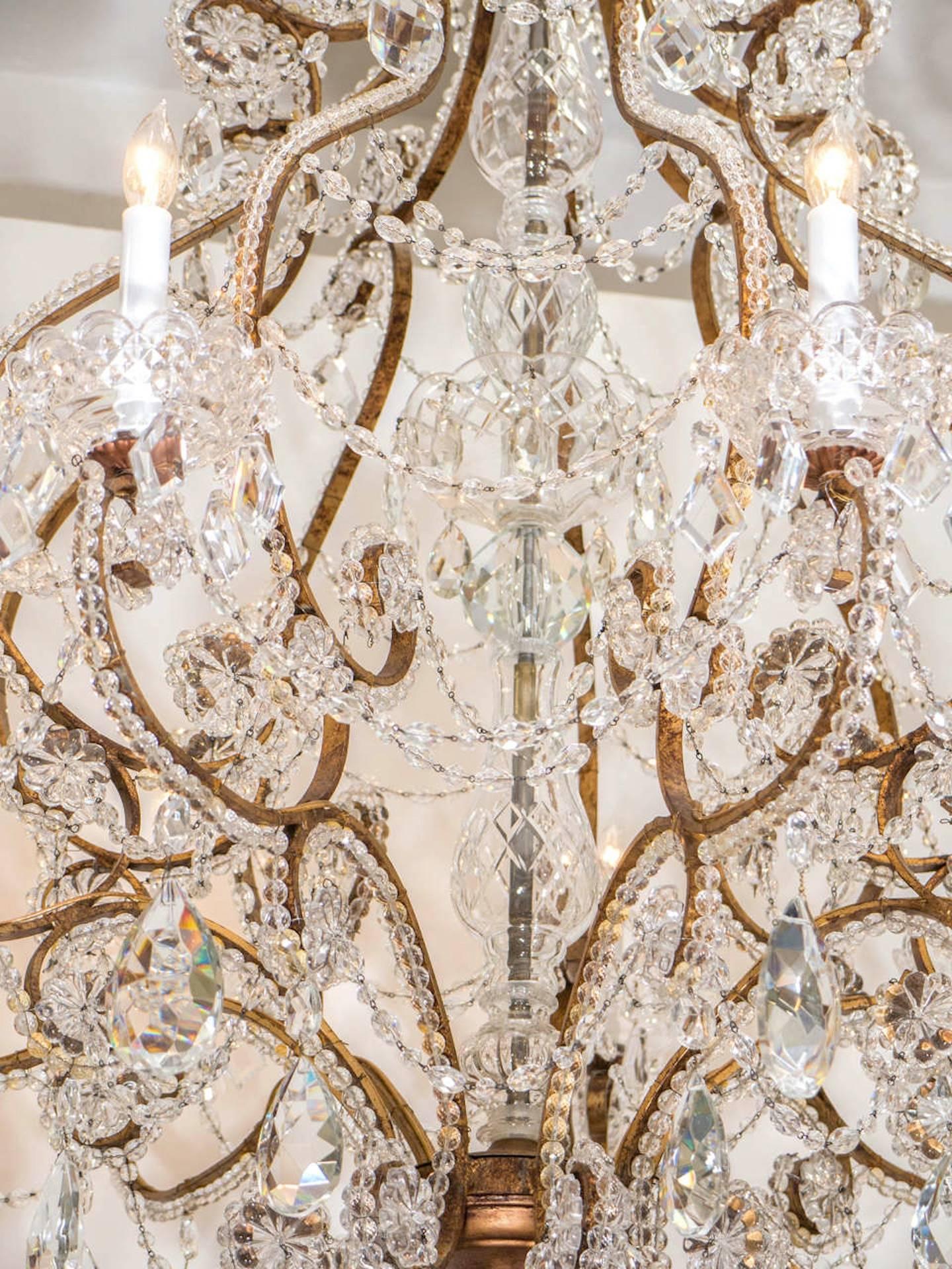 Majestic and fanciful gilt iron framed chandelier adorned with strands of faceted crystal beads and drops. Chandelier has nine-light sources surrounded by an etched crystal bobeches and have been rewired for use in the USA. A stunning addition to