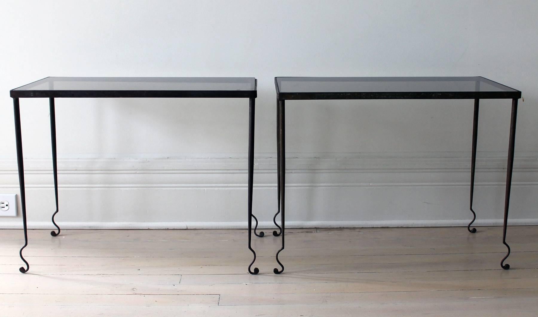 Exquisite French iron base tables from 1930s. The rectangular, brown smoky glass top raised on tapered cylindrical legs terminating with scrolled feet. Published in: Decoration Au'jourd'hui No 16 1936 cover illustration of the tables.