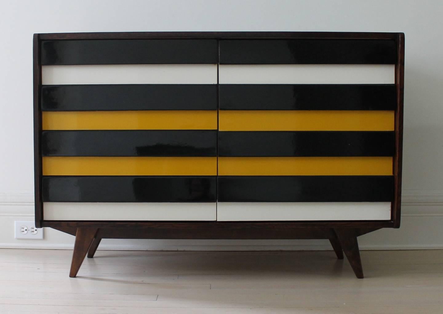 Walnut chest of drawers designed by Jiri Jirontek for: Interier Praha. 
Walnut structure, high gloss black, white and yellow painted wood drawers. 
Four drawers on each side.