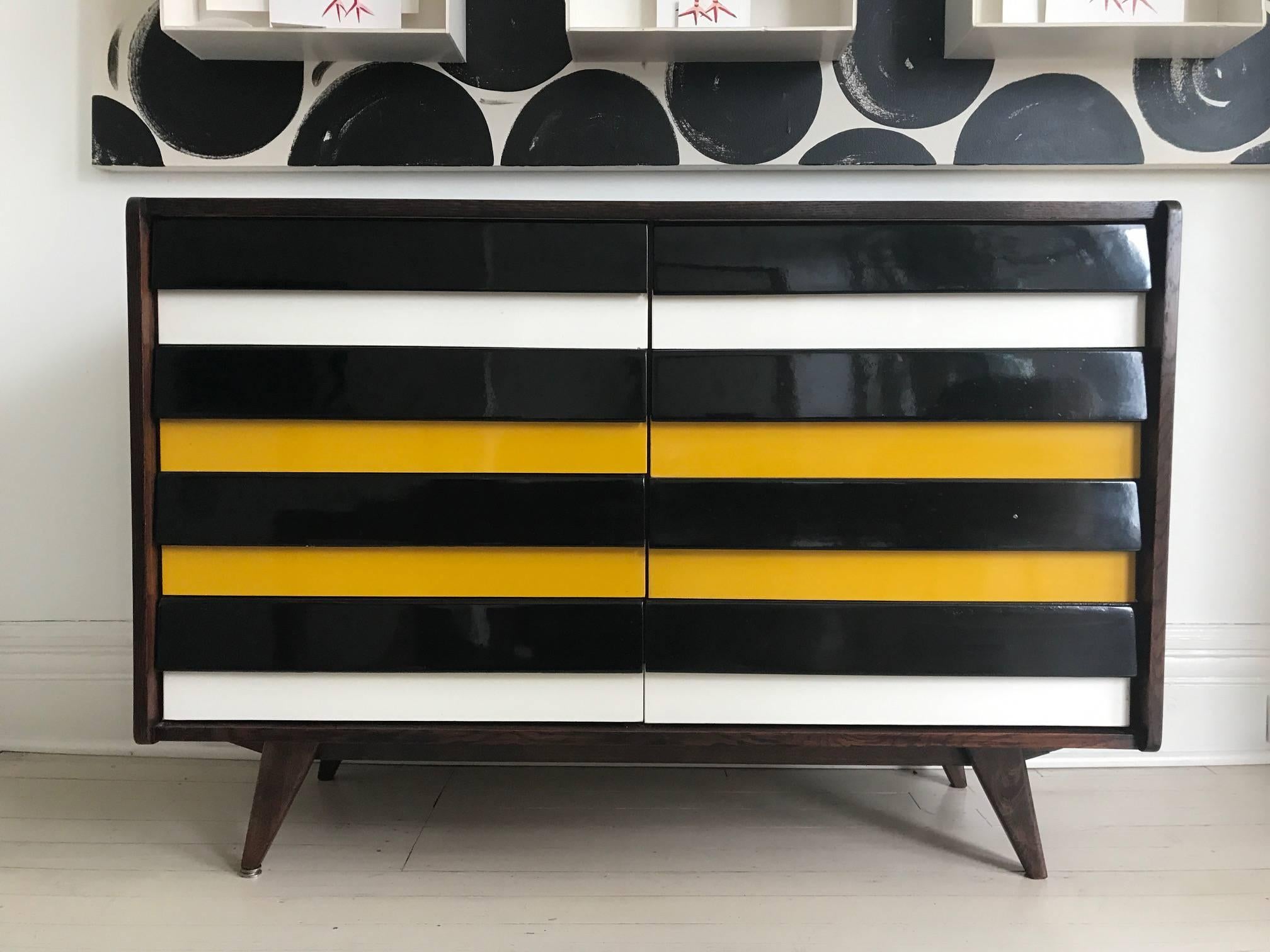 Walnut chest of drawers designed by Jiri Jiroutek for Interier Praha. High gloss black, white and yellow wood drawers four on each side.