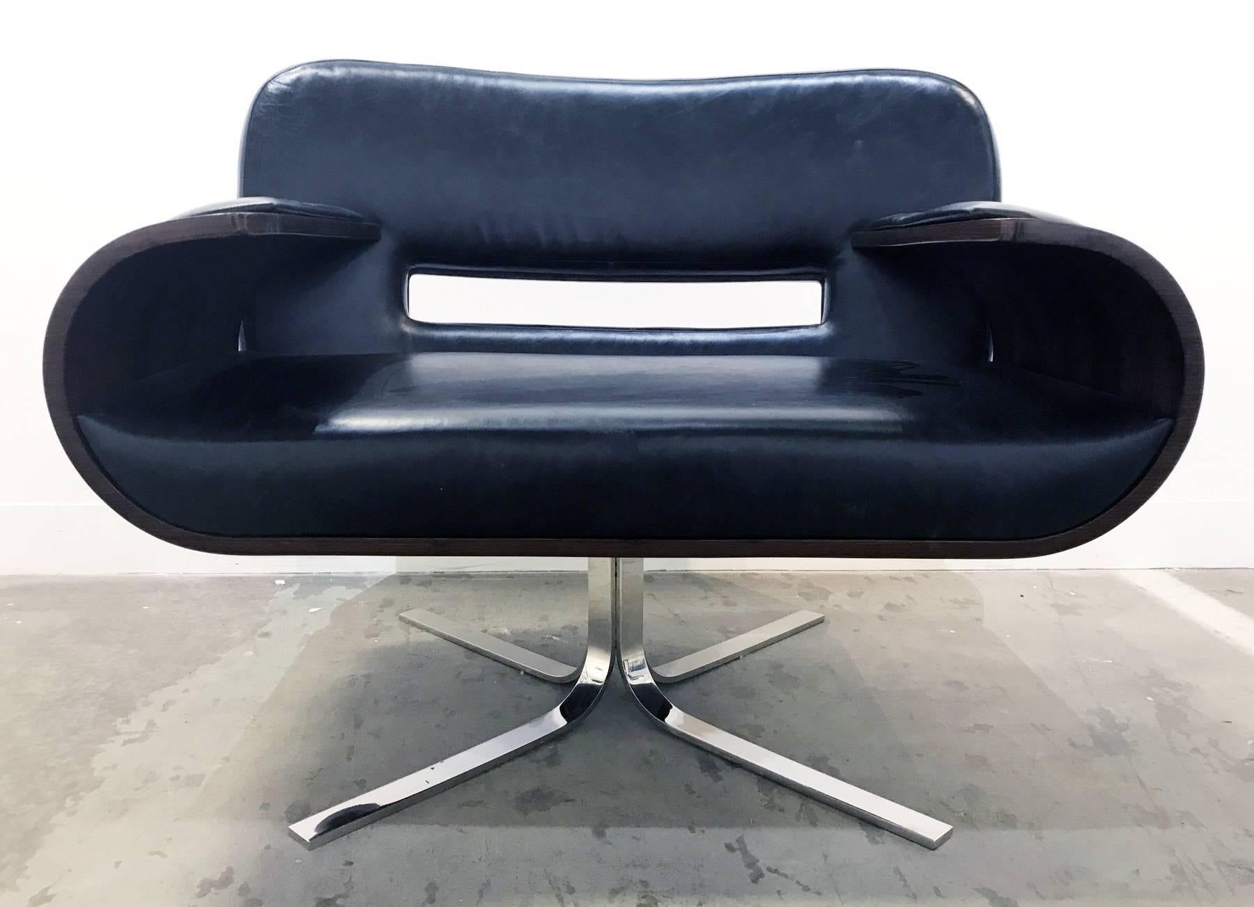 Brazilian leather and rosewood armchair designed by Jorge Zalszupin.
Bend rosewood plywood shell is upholstered in black leather and supported by stainless steel legs. Incredibly comfortable wide seat swivels on a metal structure.