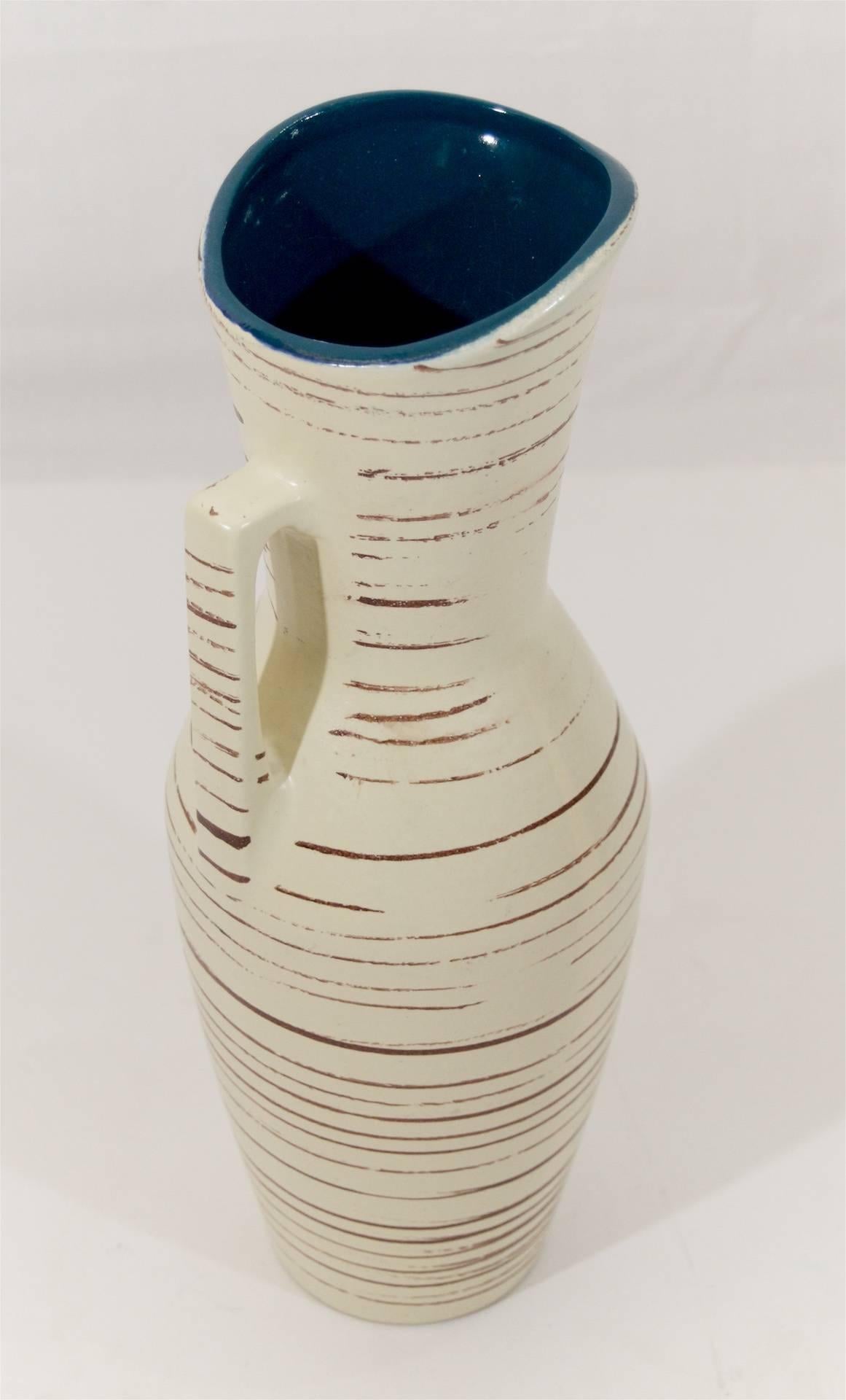 Elegantly proportioned ewer by Scheurich Keramic, the outer surface with an earthen-tone striated glaze, and a deep ultramarine blue glaze on the interior.
