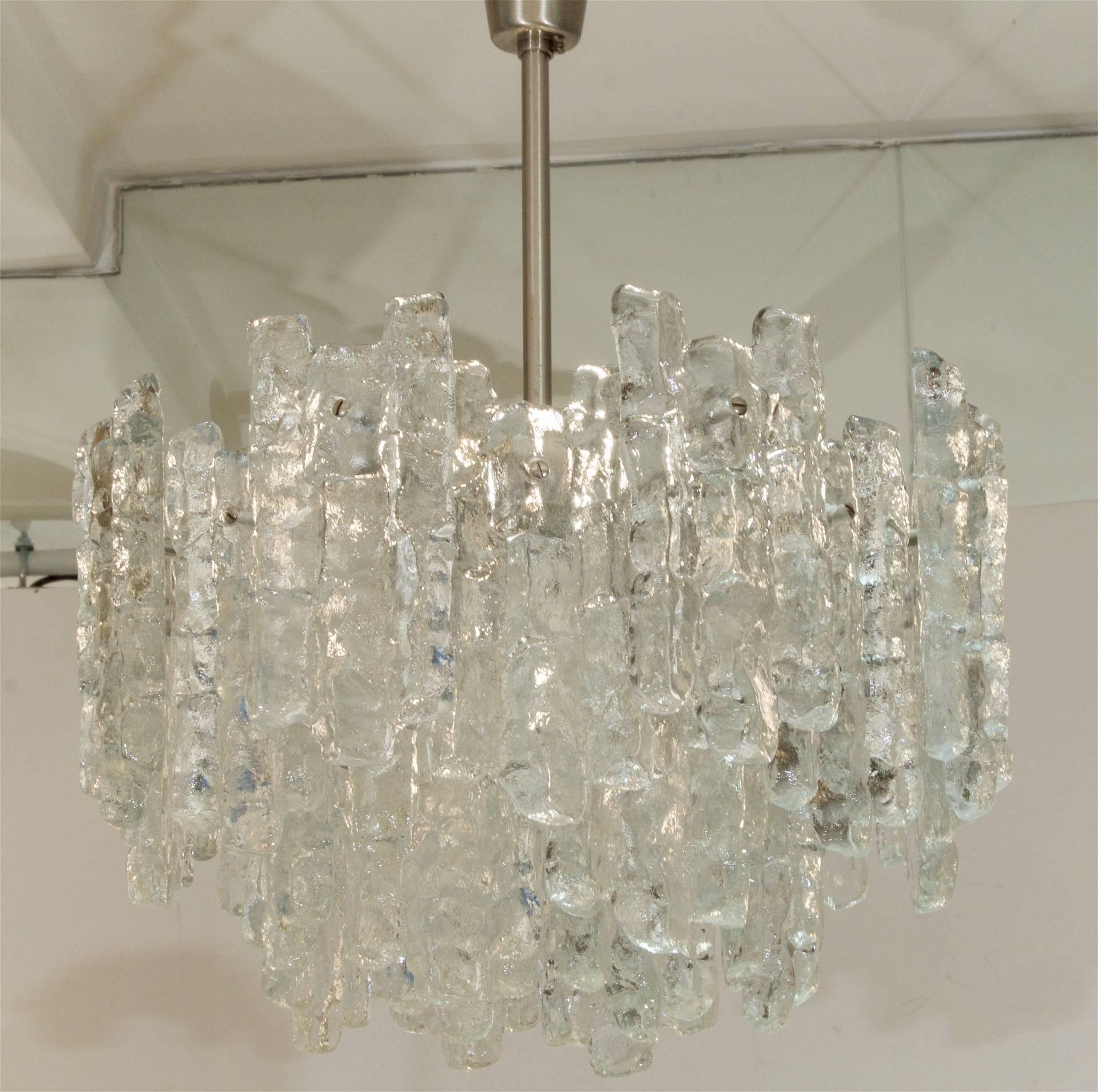28 individual pieces of solid glass in the form of ice radiate from the body in two multiple tiers. Fixture metal is nickel tone. Largest typical format of chandelier in this glass pattern.
 
Height listed is of chandelier body only, height as
