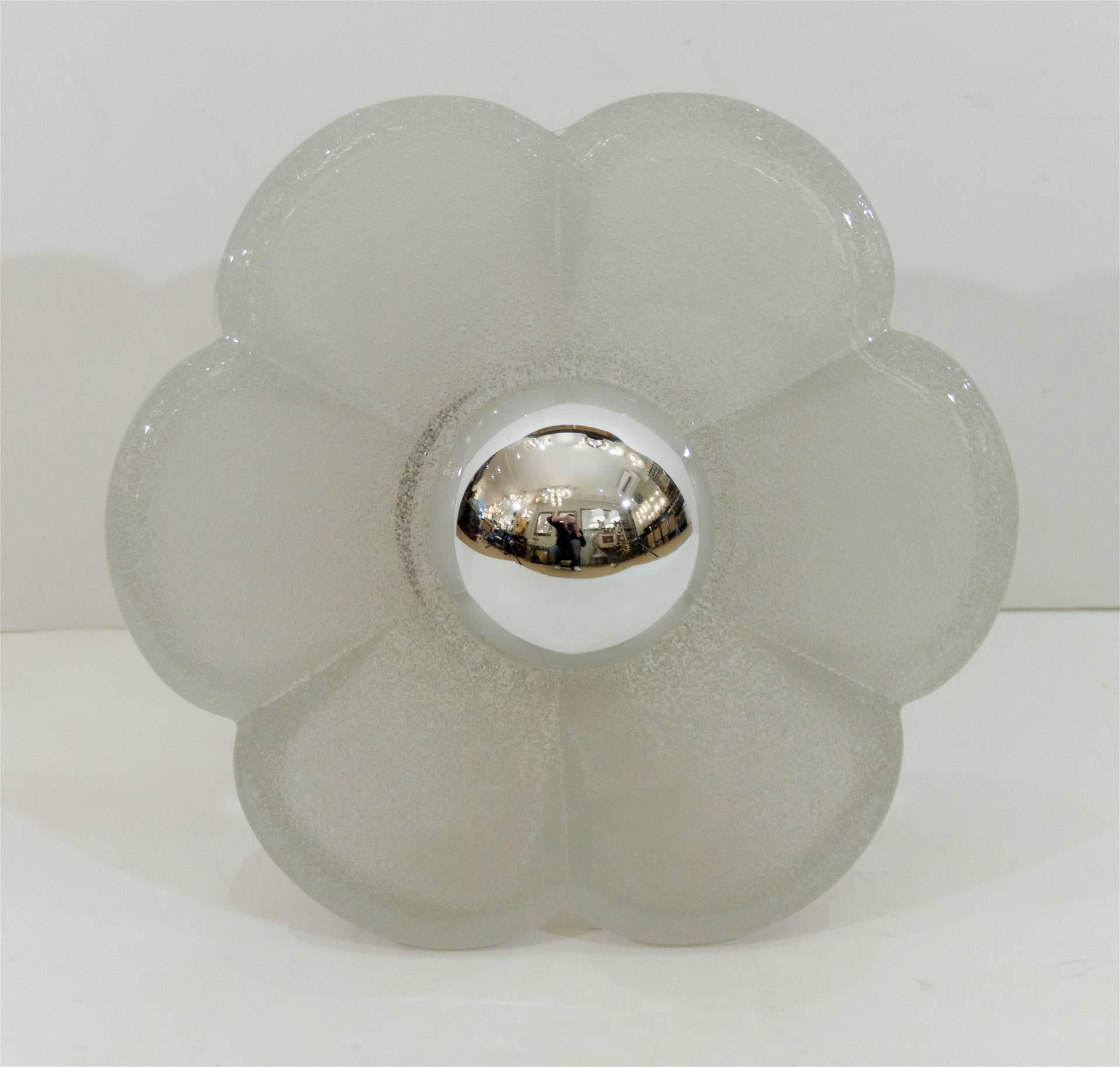 Substantial wall sconces in the form of a flower, the heavy solid glass diffuser mounted on a brass backplate. Designed for an exposed center bulb, shown with half-chrome globe bulb (not included). Uncertain manufacturer, possibly